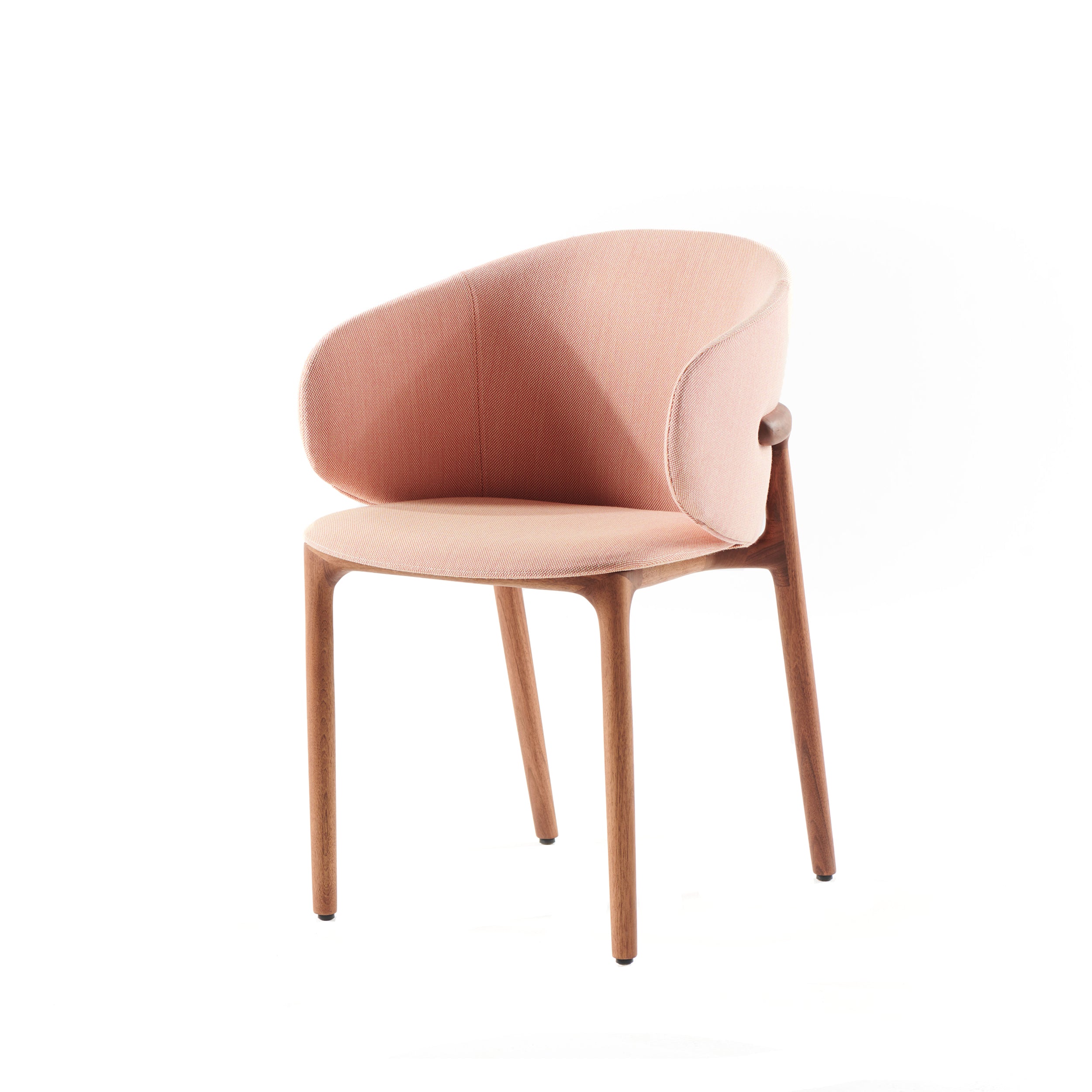 Introducing the Artisan Mela Chair—an elegant, modern twist on mid-century design with a light pink upholstered backrest, sleek curved lines, wooden legs, and an ergonomic form against a crisp white backdrop.