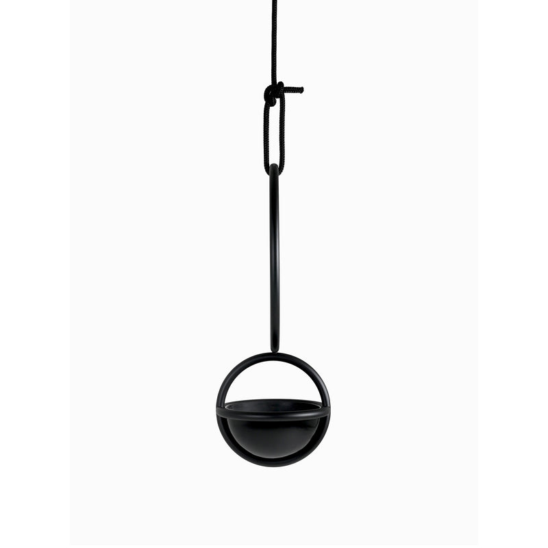 Atelier Haussmanns Blumenkugel - Hanging Flower Bowl, made of black powder-coated steel, elegantly hangs from a knotted black cord. Its spherical pot and semicircular handle embody modern minimalism against a plain white background.