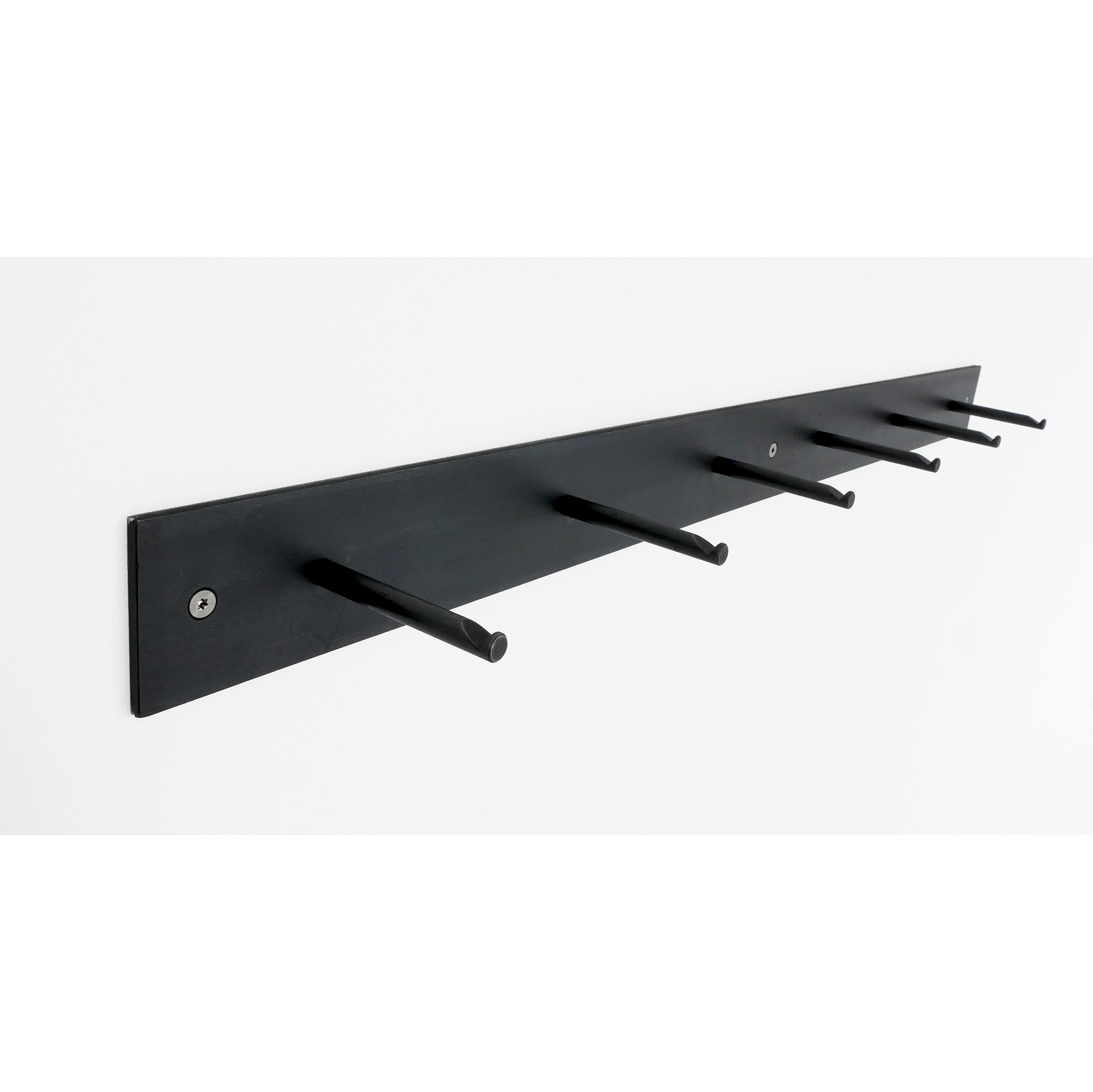 Atelier Haussmanns HELLOGOODBYE is a minimalist wall-mounted coat rack in black, featuring six evenly spaced pegs crafted from white powder-coated steel for a sleek contrast.