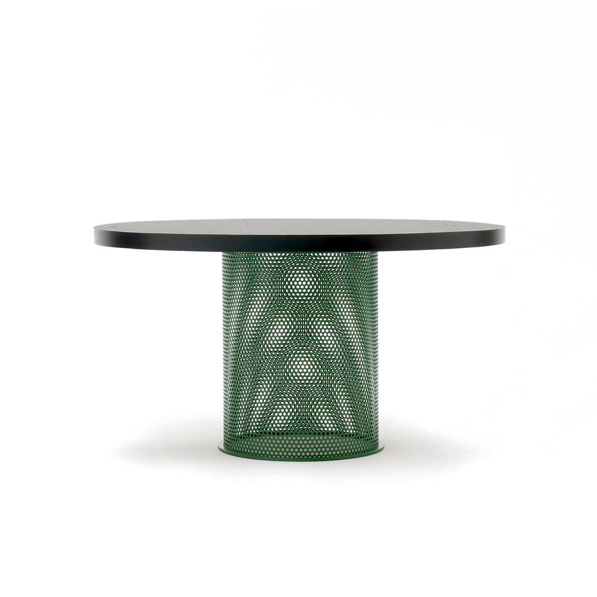 The Atelier Haussmann Leipzig Table features a sleek black or ash wood top, a unique green perforated steel cylindrical base with a geometric pattern, and is set against a plain white background.