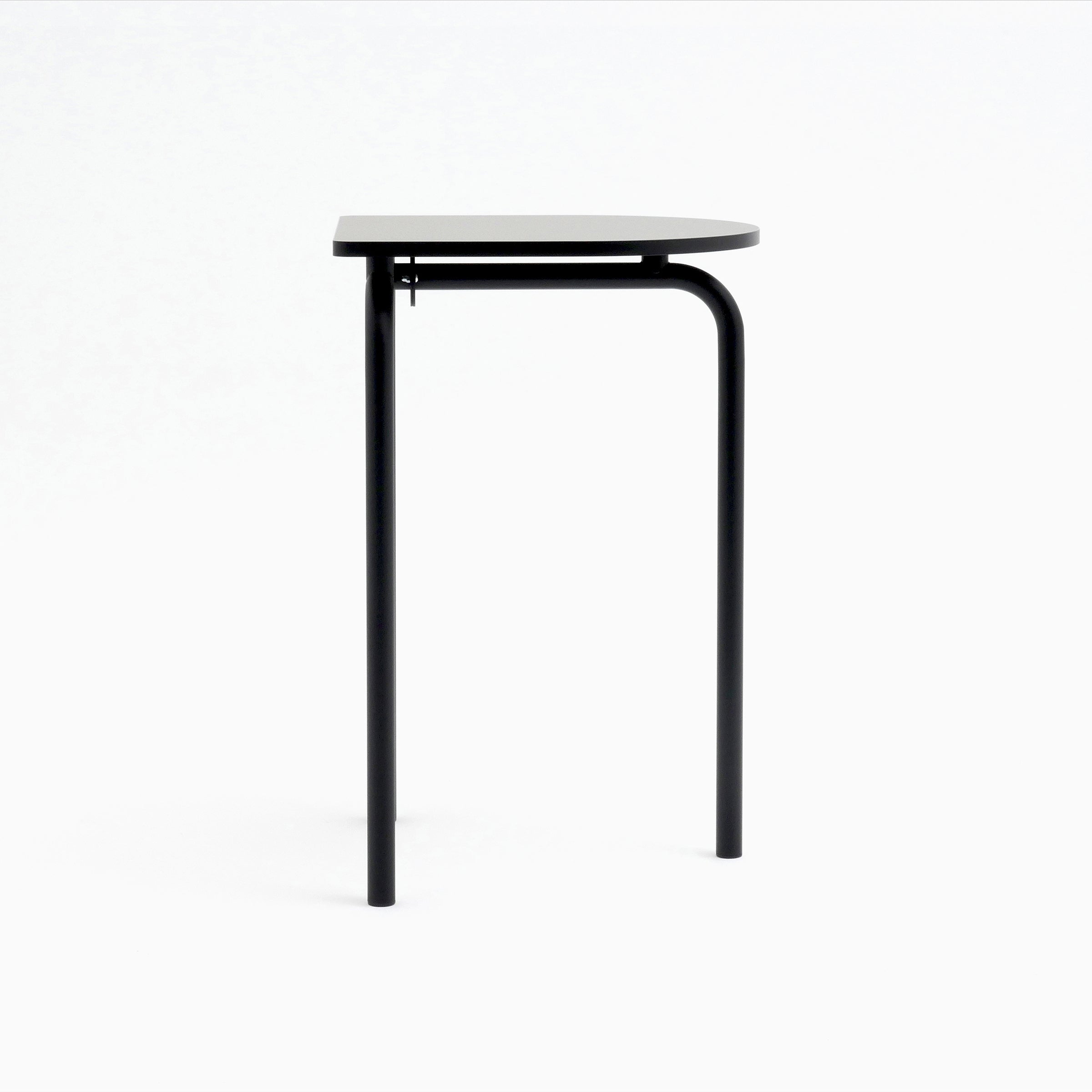 Introducing the Piombino Alto 700 table by Atelier Haussmann: a minimalist half-circle black design with industrial elegance and two sturdy legs. Ideal for modular setups, its flat edge attaches seamlessly to the wall while the curved side stands out against a white background.