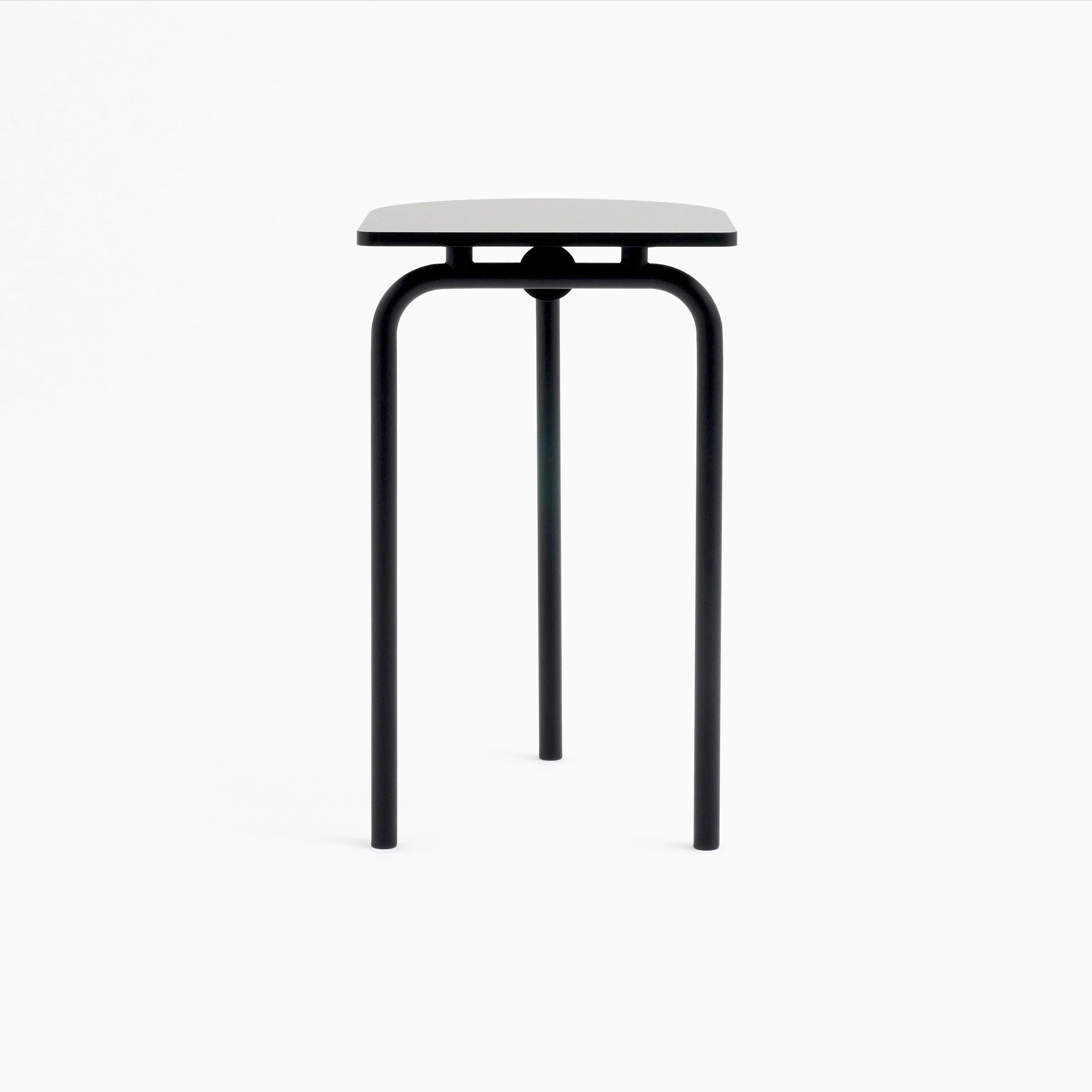 The Piombino Alto 700 by Atelier Haussmann is a minimalist stool featuring a square white seat and three black metal legs, showcasing an industrial design against a plain white background.