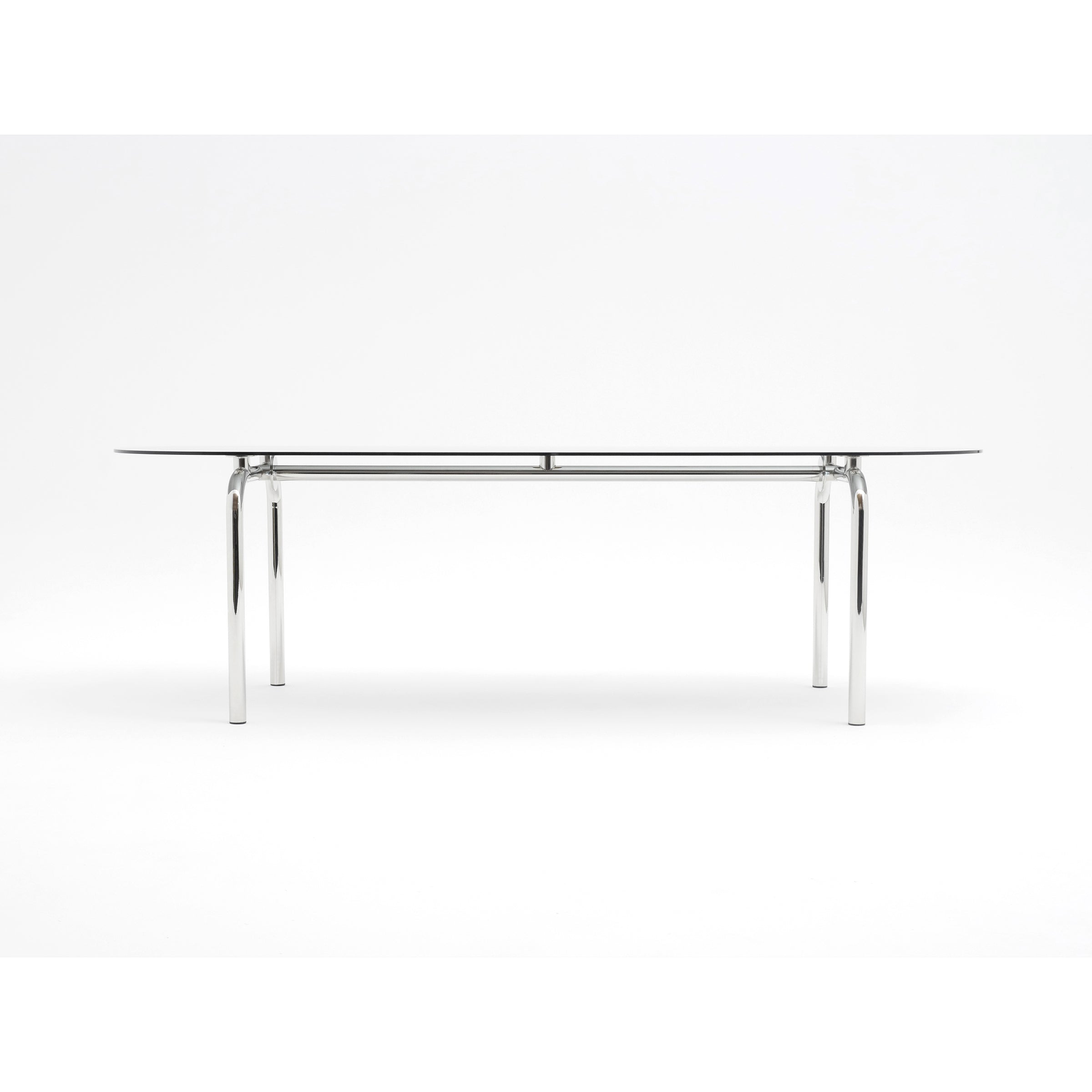 Introducing the Piombino Basso Table by Atelier Haussmann, a modern masterpiece with a sleek glass top and shiny curved steel tube legs. It stands out against a plain white background, embodying elegance and contemporary style.