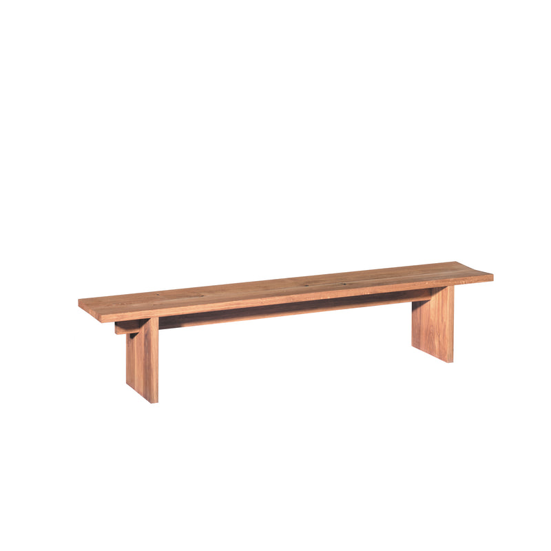 The BE02 TARO by E15, designed by Philipp Mainzer, exudes minimalist elegance with a long rectangular seat supported by two sturdy legs. It features light brown wood with visible grain patterns against a white backdrop.