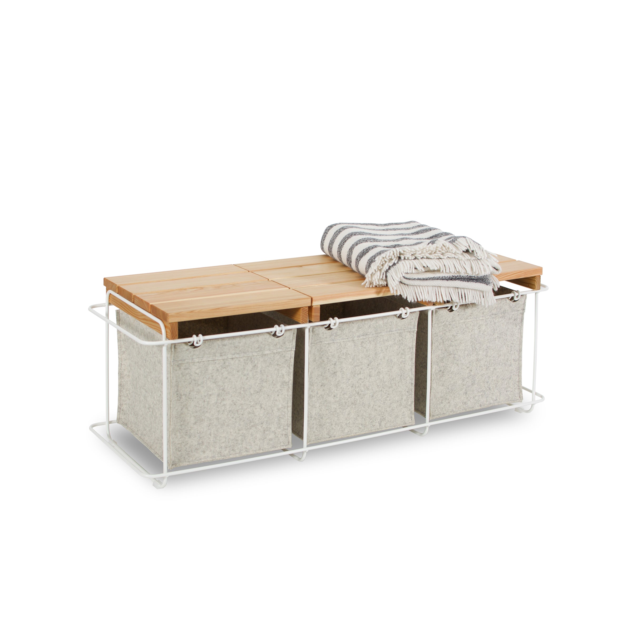 The Bartmann Berlin Grit Indoor storage bench includes a powder-coated stainless steel frame, three gray fabric bins, and a wooden top, with a gray and white striped blanket draped over it.