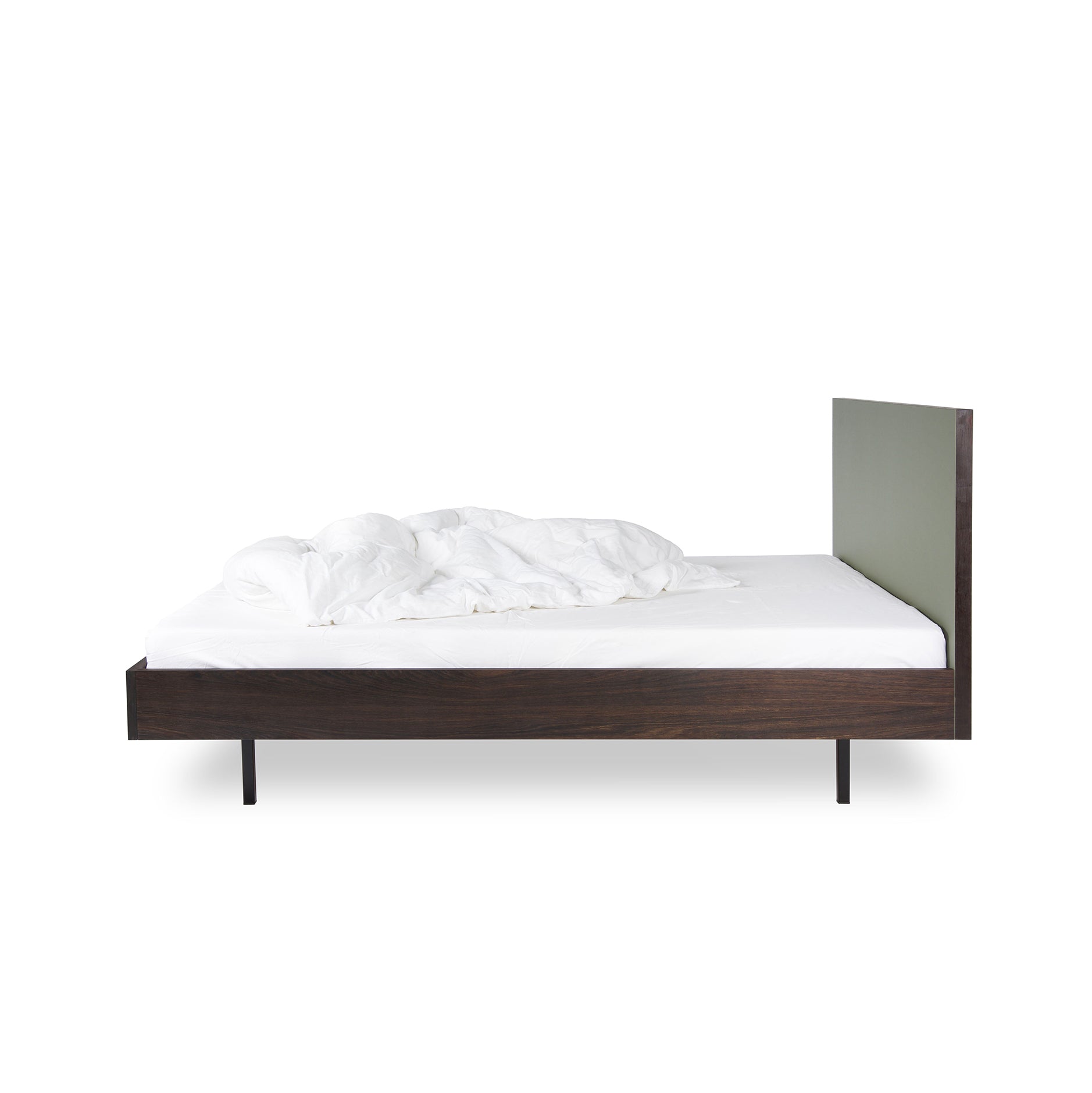 Side view of the Unidorm Bed Olive by Bartmann Berlin, showcasing an elegant smoked oak frame and minimalist headboard. The bed has a white sheet and crumpled duvet, set against a plain white background, blending style with simplicity.