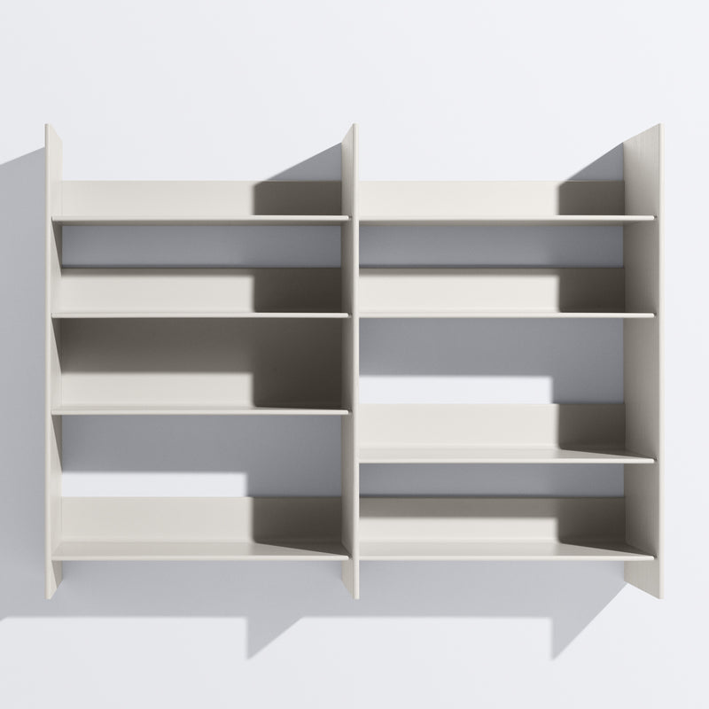 The Graph by Bartmann Berlin is a minimalist wall-mounted shelving unit in light gray, featuring two sections with three evenly spaced shelves each, accentuating its geometric design against a white wall.