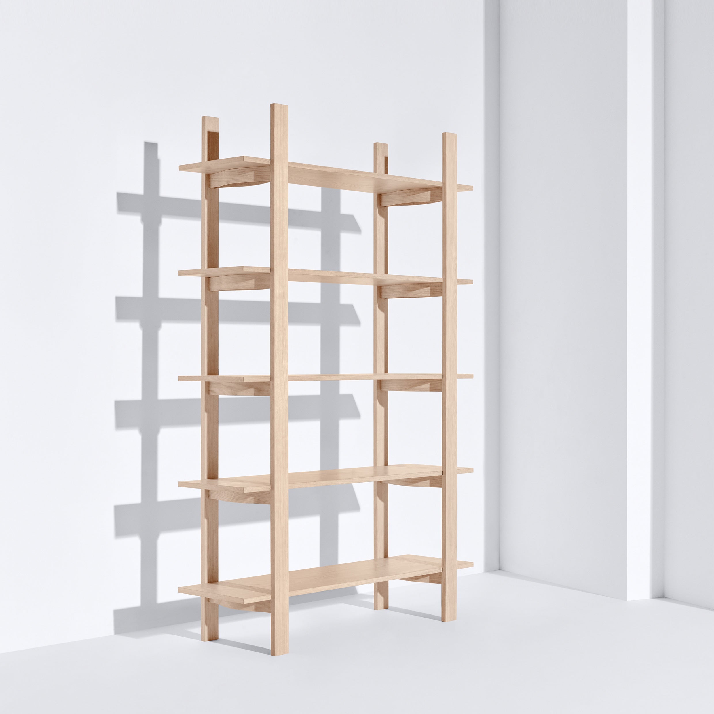 The Tonus shelf by Bartmann Berlin is a minimalist solid oak unit with six evenly spaced shelves and vertical beams, casting a soft shadow on its plain white backdrop.
