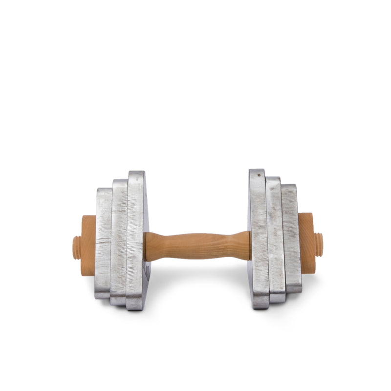 A metal dumbbell with adjustable square weights and a sleek maple wood handle sits on a plain white background, showcasing the minimalist design of Bartmann Berlins Trimm Dich.