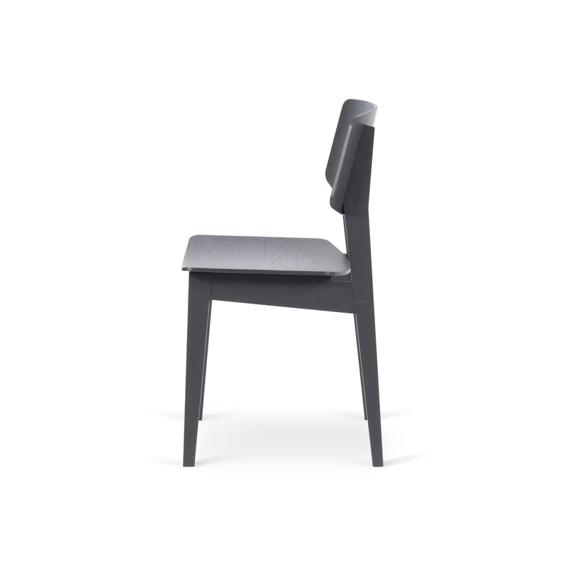 Side view of the Bartmann Berlin Usus Chair with a minimalist design and natural elegance, showcasing a modern black finish, straight backrest and seat, clean lines, and four oak legs against a plain white background.