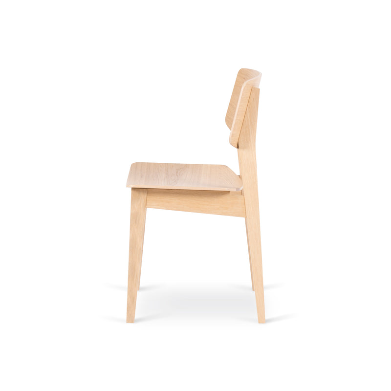 Side view of the Usus Chair by Bartmann Berlin, featuring a minimalist oak design with a flat seat, slightly angled backrest, and straight legs. It showcases natural elegance in a light wood finish against a plain white background.