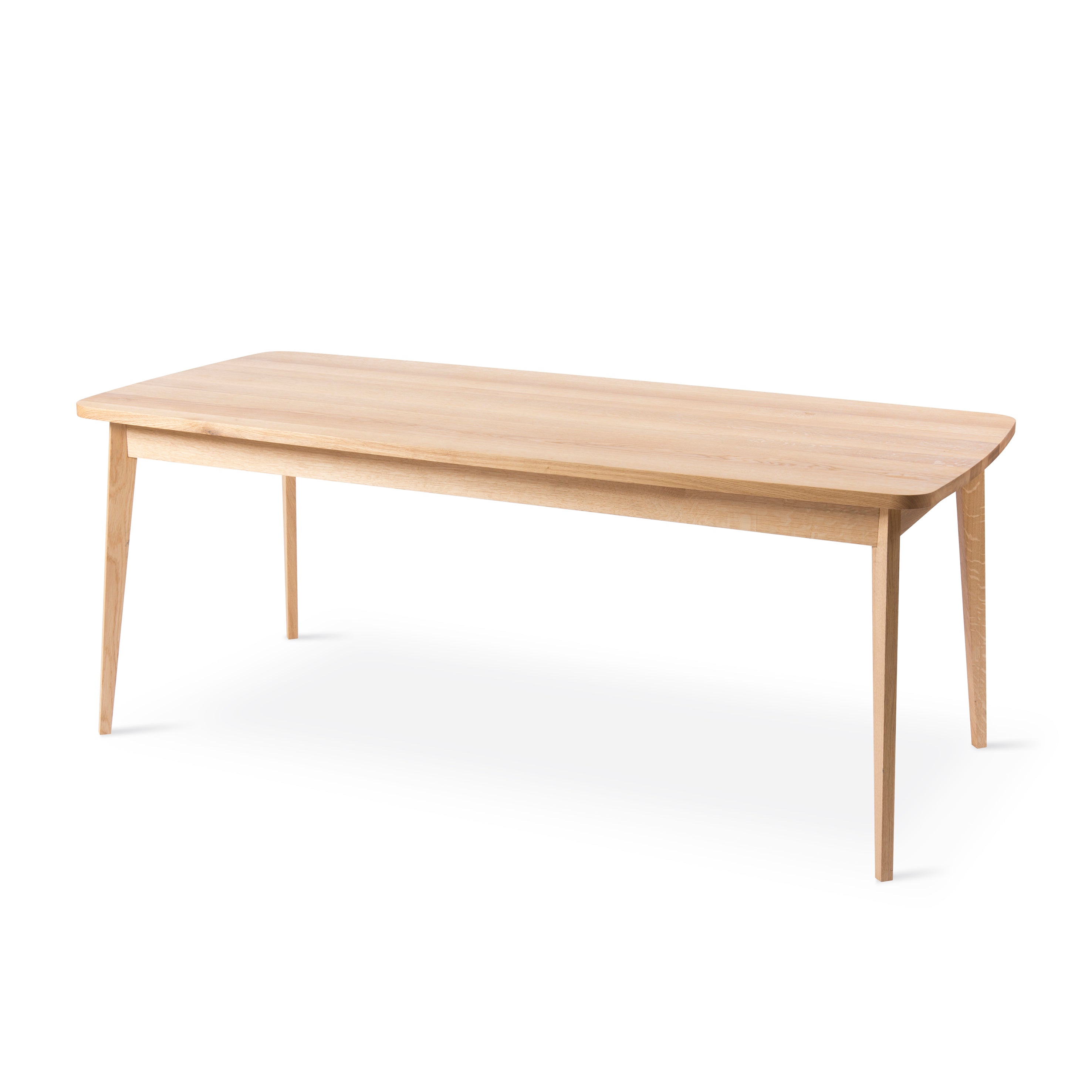 The Usus Table by Bartmann Berlin is a minimalist wooden coffee table made from European oak with a light natural finish, featuring a rectangular top with slightly rounded edges and four tapered legs, embodying the collections elegance.