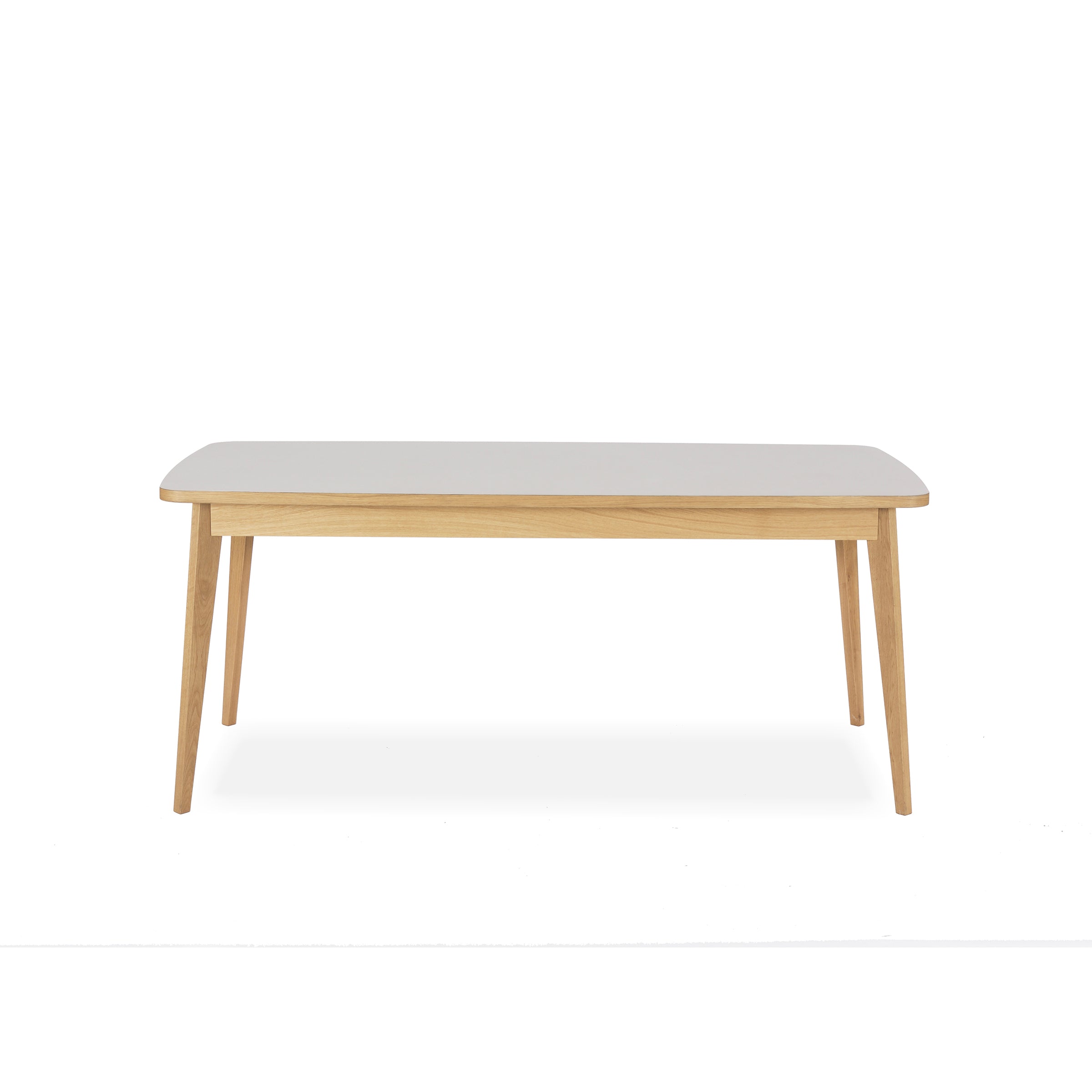 The Usus Table by Bartmann Berlin is a rectangular coffee table with a white, linoleum-coated top and light European oak legs set against a plain white backdrop.