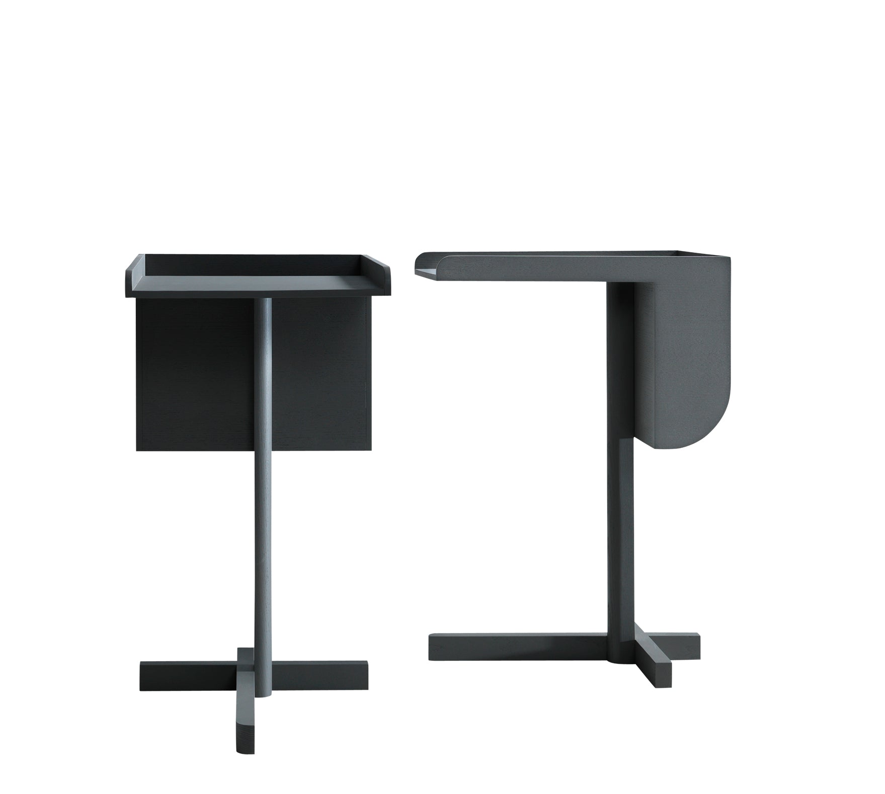 These minimalist side tables from Boewers School collection echo Konstantin Grcics functional elegance. With dark gray finishes, one has a rectangular top and flat side while the other is rounded, both perched on cross-shaped bases with unique geometries.