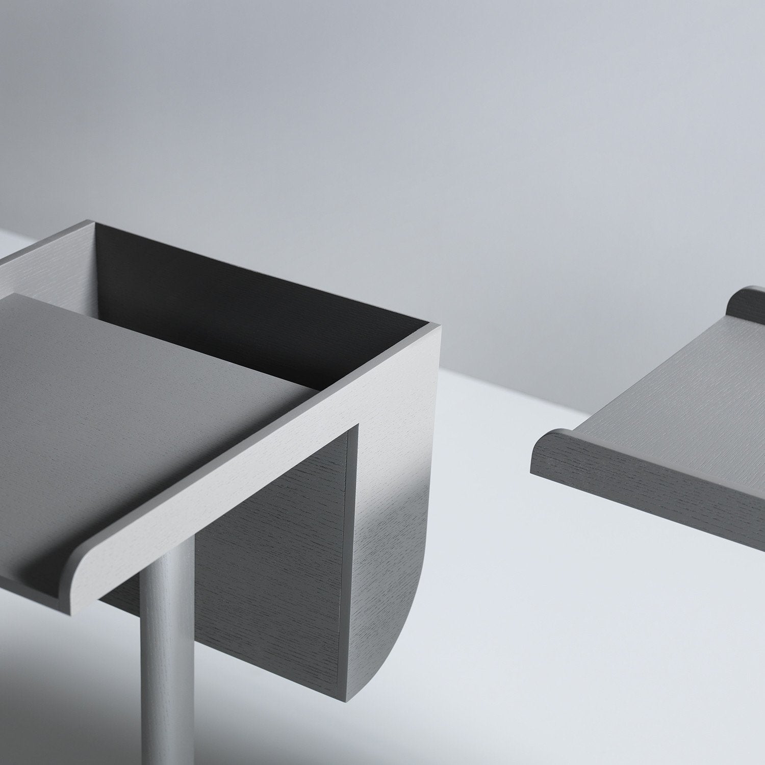 Close-up of a modern School table by Boewer, echoing Konstantin Grcics style in light grey. The minimalist design boasts sleek, angular lines with a curved edge and supporting pole, set against a plain background to highlight its clean, contemporary appeal.