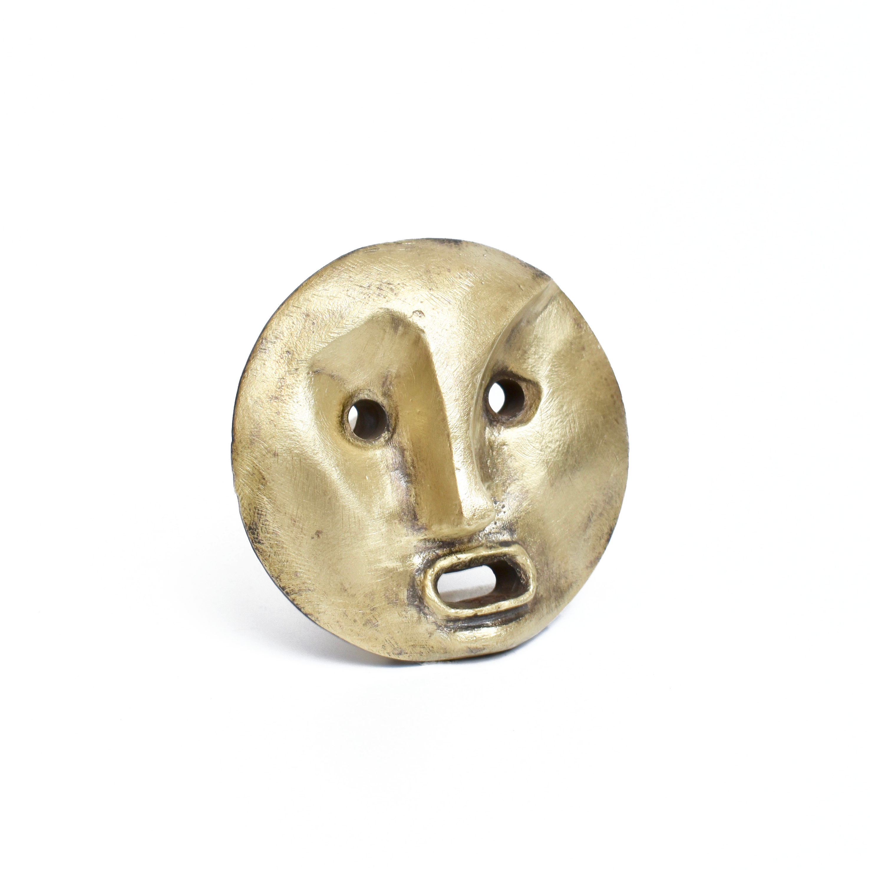 Bottle Stopper Pluto #4686 by Werkstätte Carl Auböck is a small, round sculptural mask with exaggerated features like thick eyebrows, a prominent nose, and an open mouth. Made from a bronze-like material reminiscent of Wiener Bronzen, its elegantly set against a plain white background.