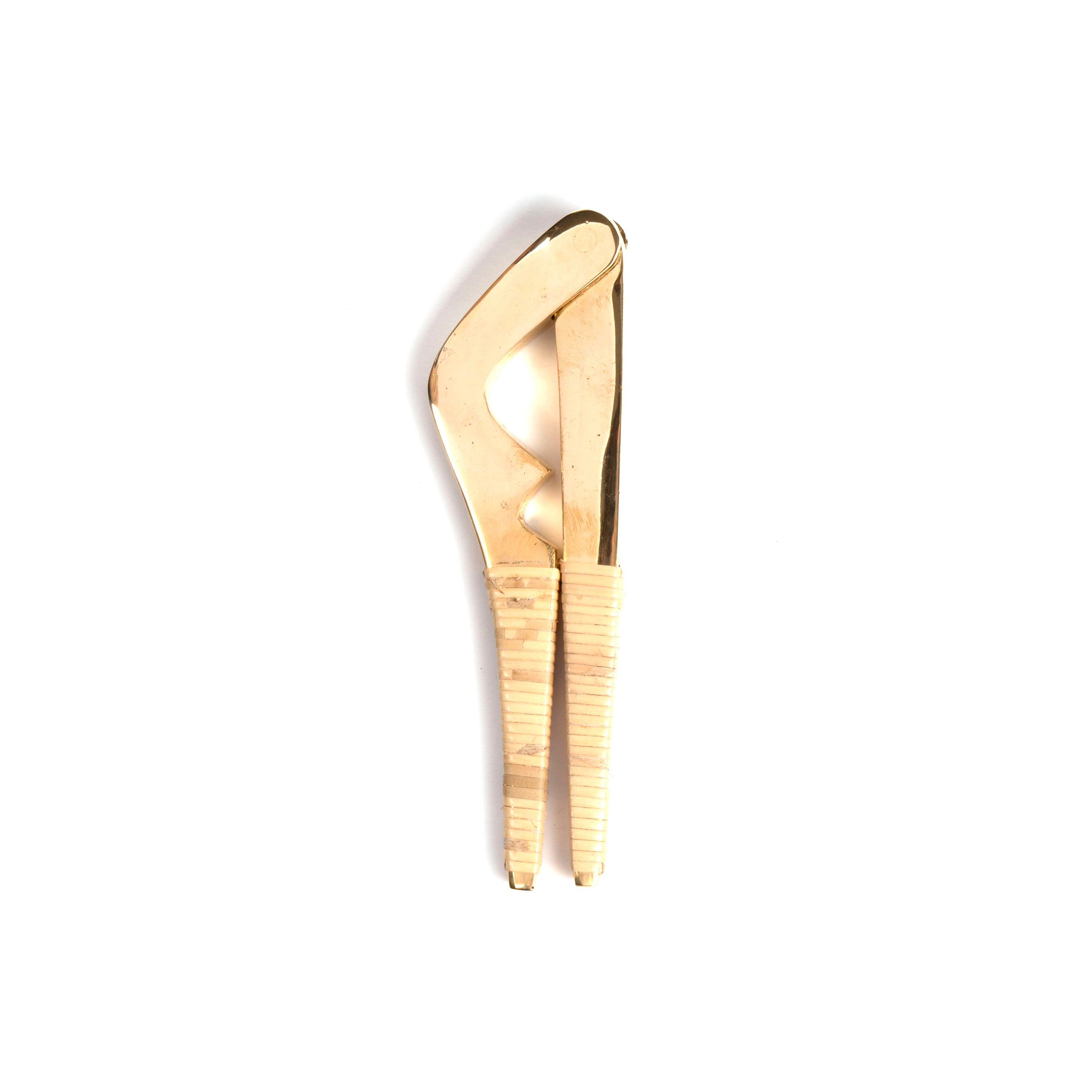 The Nutcracker #4234 by Werkstätte Carl Auböck features a gold metallic finish with a curved design and textured handle, akin to the exquisite craftsmanship of a Viennese workshop, displayed on a plain white background.