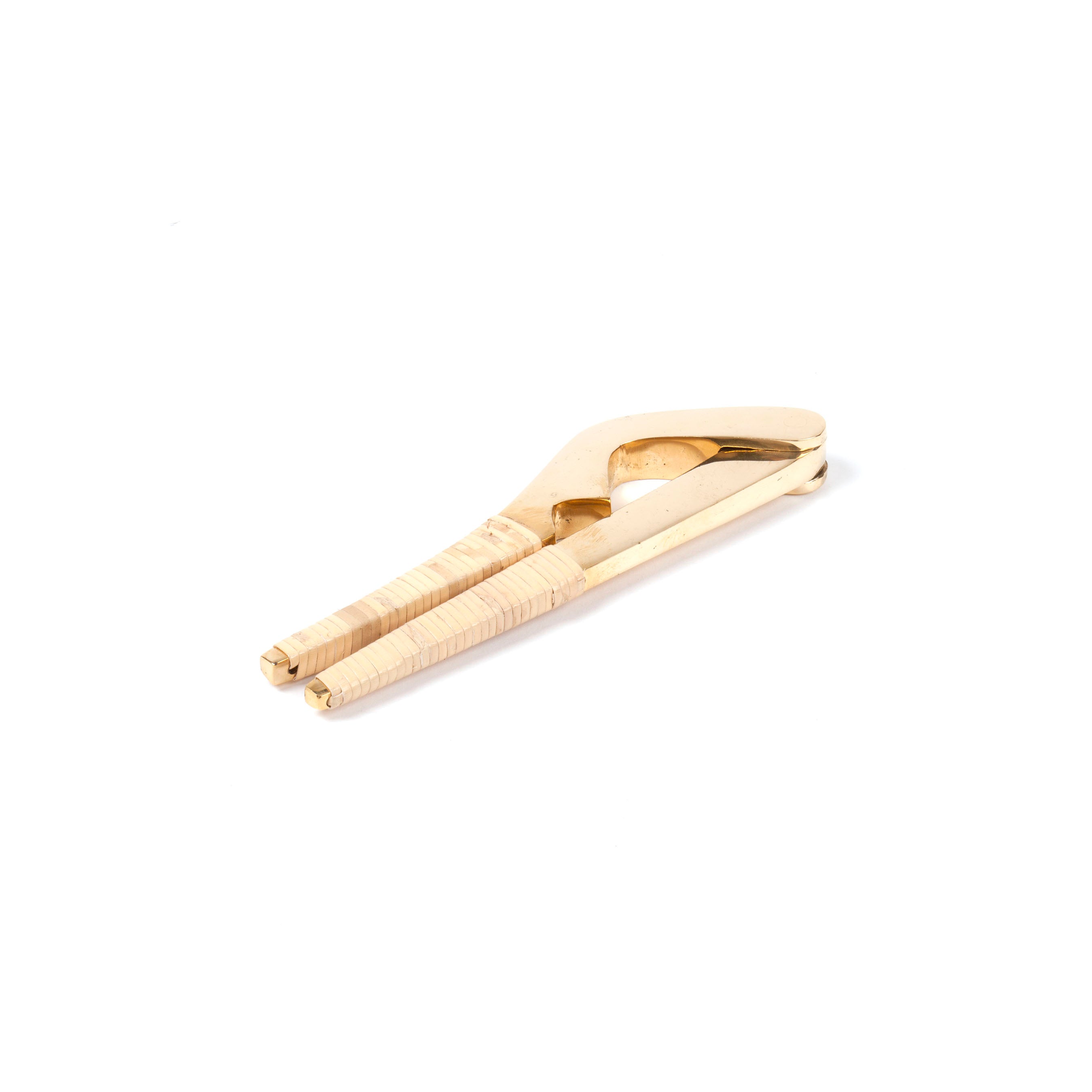 The Nutcracker #4234 by Werkstätte Carl Auböck is a sleek, gold-toned metal piece from a renowned Viennese workshop. Featuring two parallel, slightly curved arms reminiscent of tongs, its refined design mirrors the elegance of Wiener Bronzen against a pristine white background.