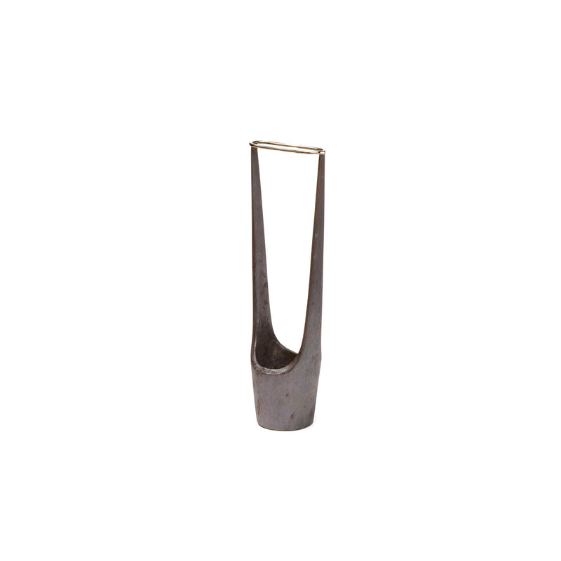 Vase #7228 by Werkstätte Carl Auböck is a metal cigar holder with a sleek, minimalist design. It features two tall, narrow prongs in a V-shape and a stable base. The smooth metallic gray finish evokes the elegance of a Viennese townhouse.