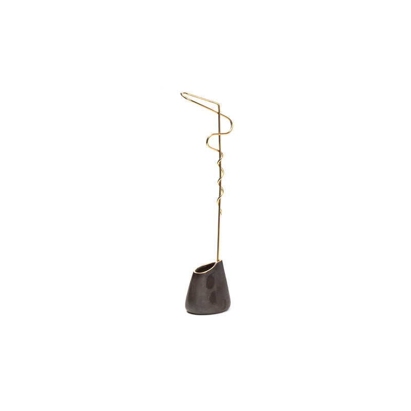 The Vase Single Noose #7240 by Werkstätte Carl Auböck is a sleek, modern sculpture featuring a curved gold wire rising from a dark conical base, capturing the minimalist elegance of Triennale di Milano as it stands against a white background.