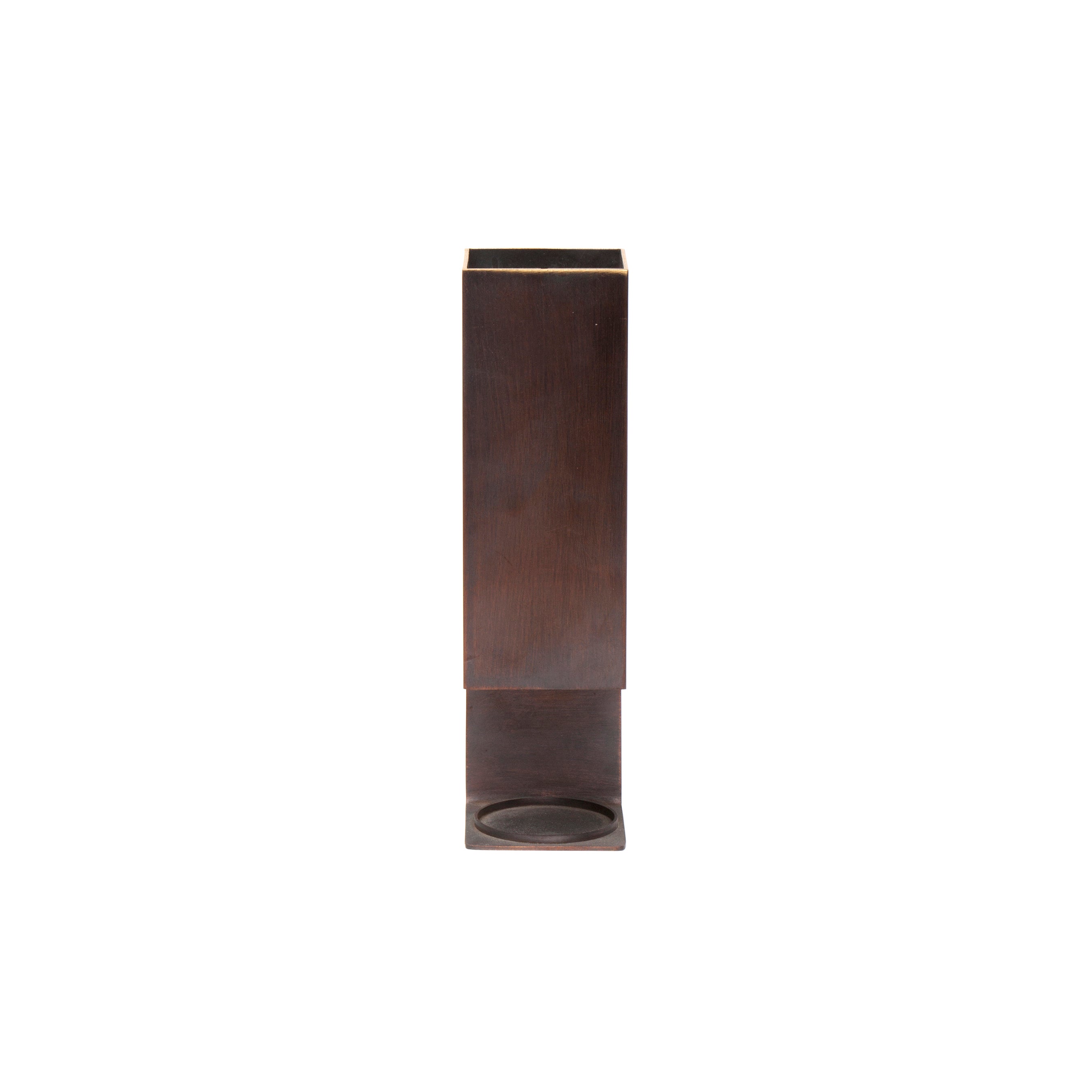 The Aroma Burner #7241 by Werkstätte Carl Auböck stands tall with a minimalist charm. Its dark brown, rectangular metal design, reminiscent of classic Auböck aesthetics, makes it a versatile addition to any modern space, serving as either a vase or container against a plain white background.