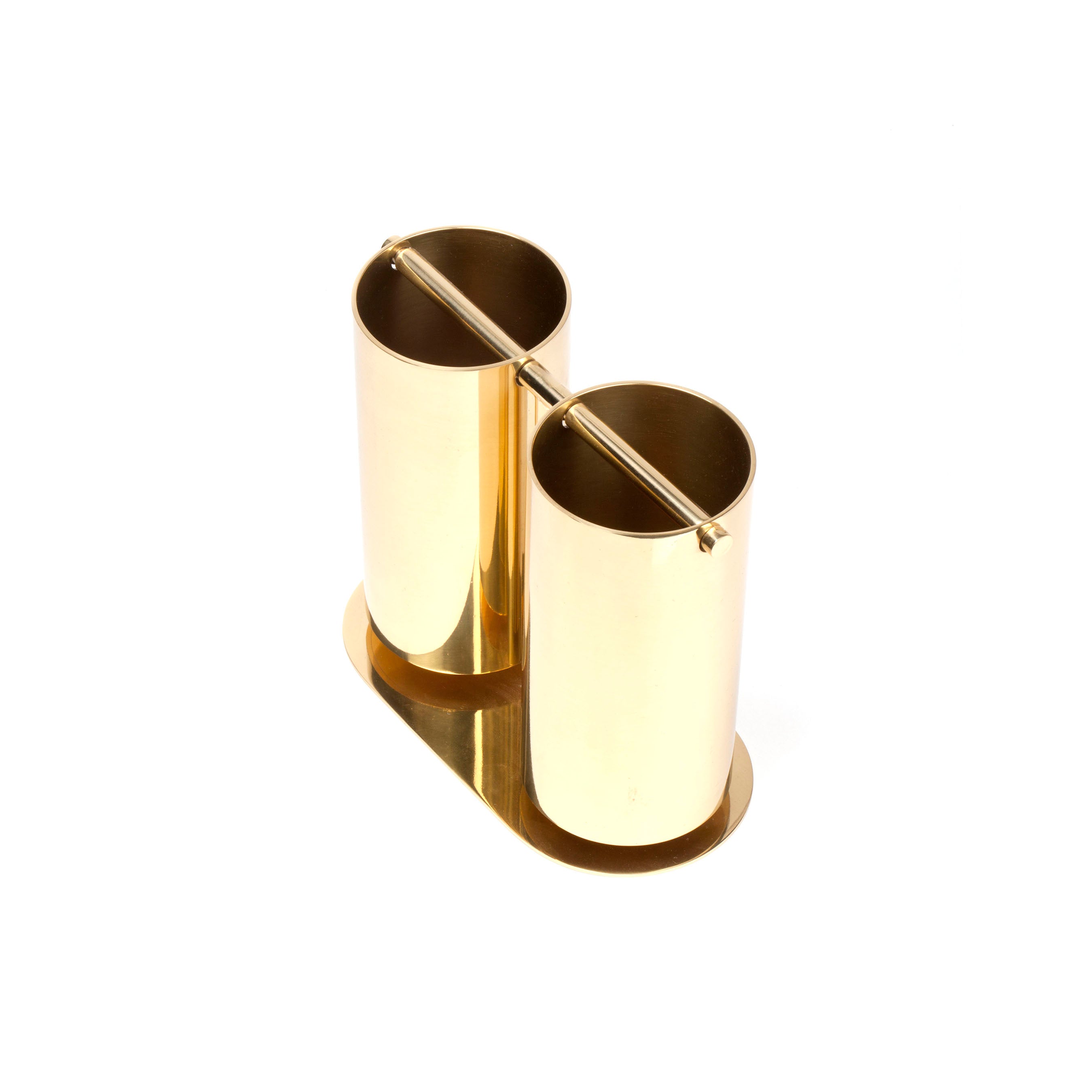 The Vase Double Swing #7246 by Werkstätte Carl Auböck is a shiny, cylindrical, gold-tone piece with two slots and a horizontal top handle, exuding elegance against a plain white backdrop.