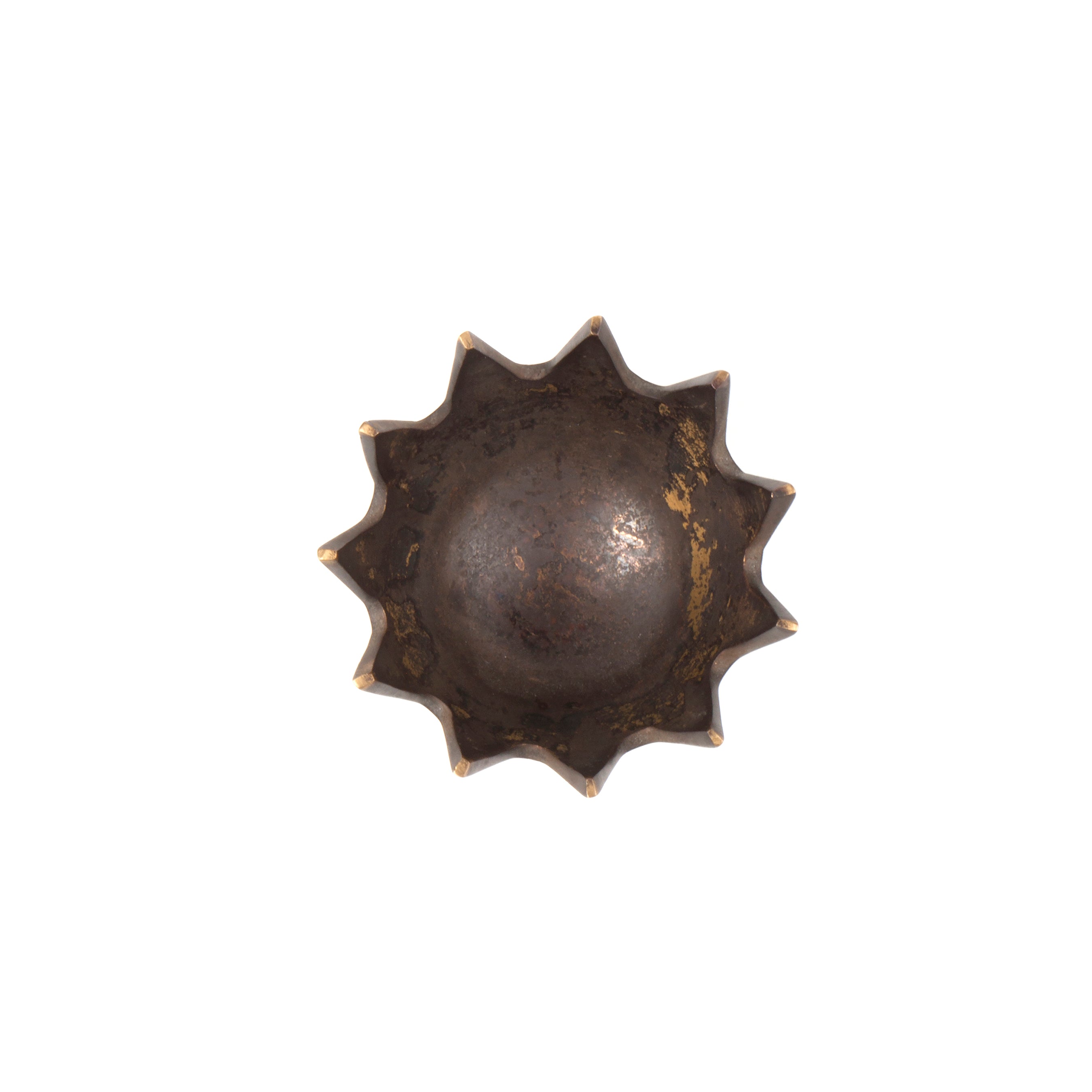 The Ashtray Crown #3600 by Werkstätte Carl Auböck features a vintage copper mold with a sunburst design. Its circular base and ridged edges resemble sun rays, while the surface is aged with tarnish, enhancing its antique charm.