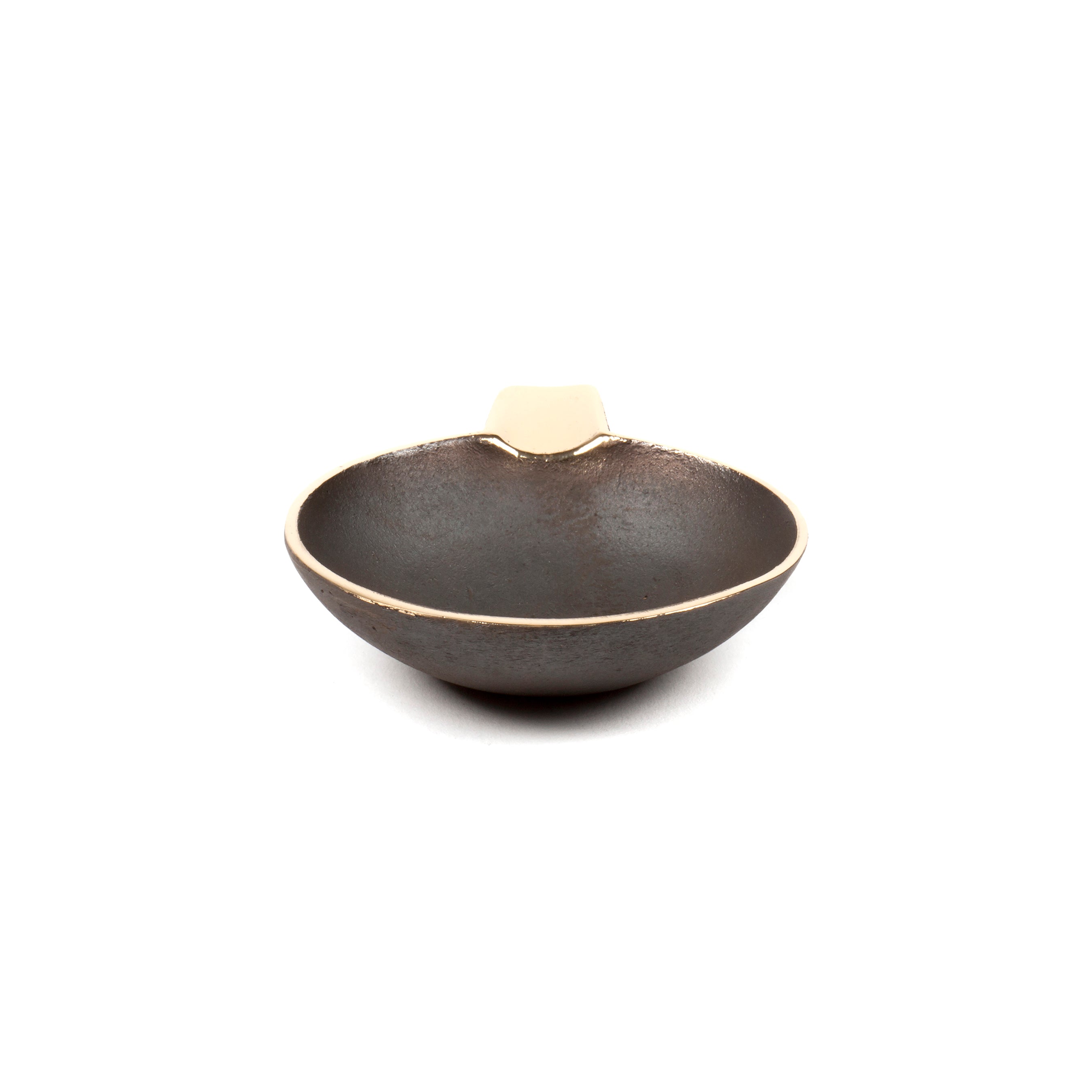 The Ashtray #4082 by Werkstätte Carl Auböck is a round, textured, dark brown dish with a small flat handle. It exudes elegance reminiscent of a classy Viennese townhouse, with its shallow design and slightly metallic look set against a white background.