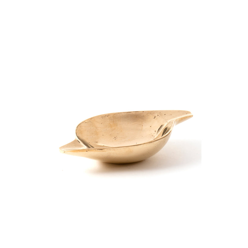 The Ashtray #4206C by Werkstätte Carl Auböck is a small, shallow brass bowl with a polished surface and two wide handles on the rim, reflecting elegant design against a plain white background.
