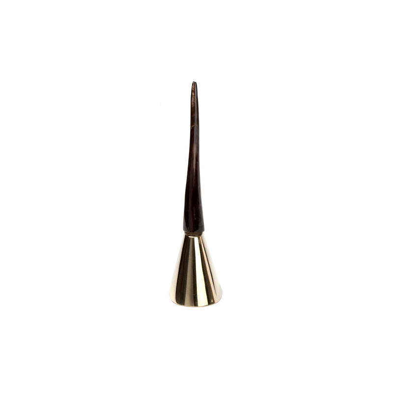 The Bell #3603 by Werkstätte Carl Auböck is a gold-toned object with a conical base and slender dark tip, set against a white backdrop, echoing the timeless elegance and artistic flair reminiscent of the Triennale di Milano 1954.
