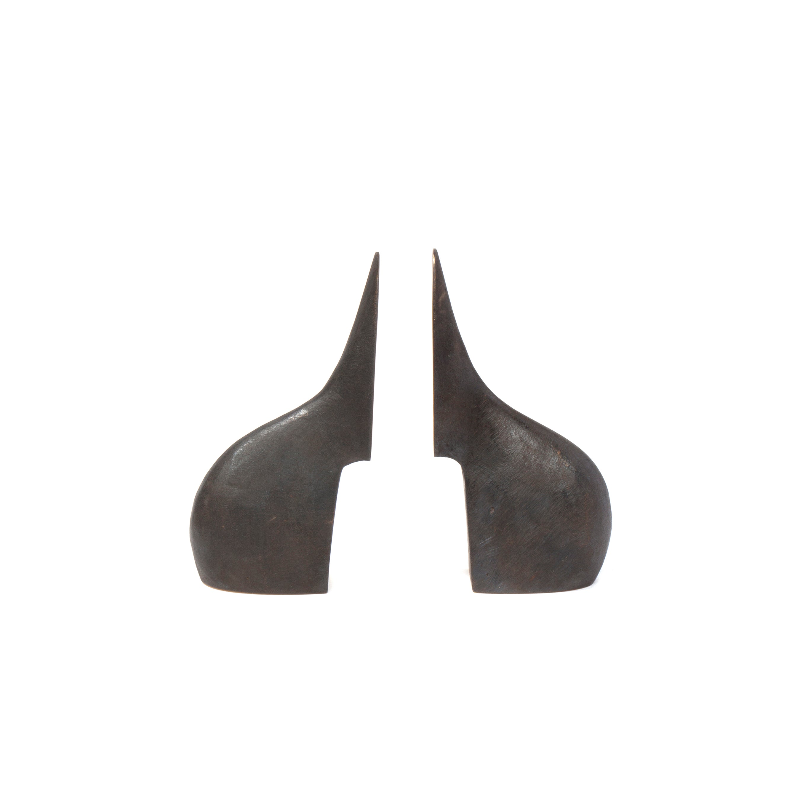 Pair of Bookends #3652 by Werkstätte Carl Auböck features two abstract, dark metal sculptures with symmetrical, curved horn-like shapes on a plain white background, evoking elegance and minimalist balance.
