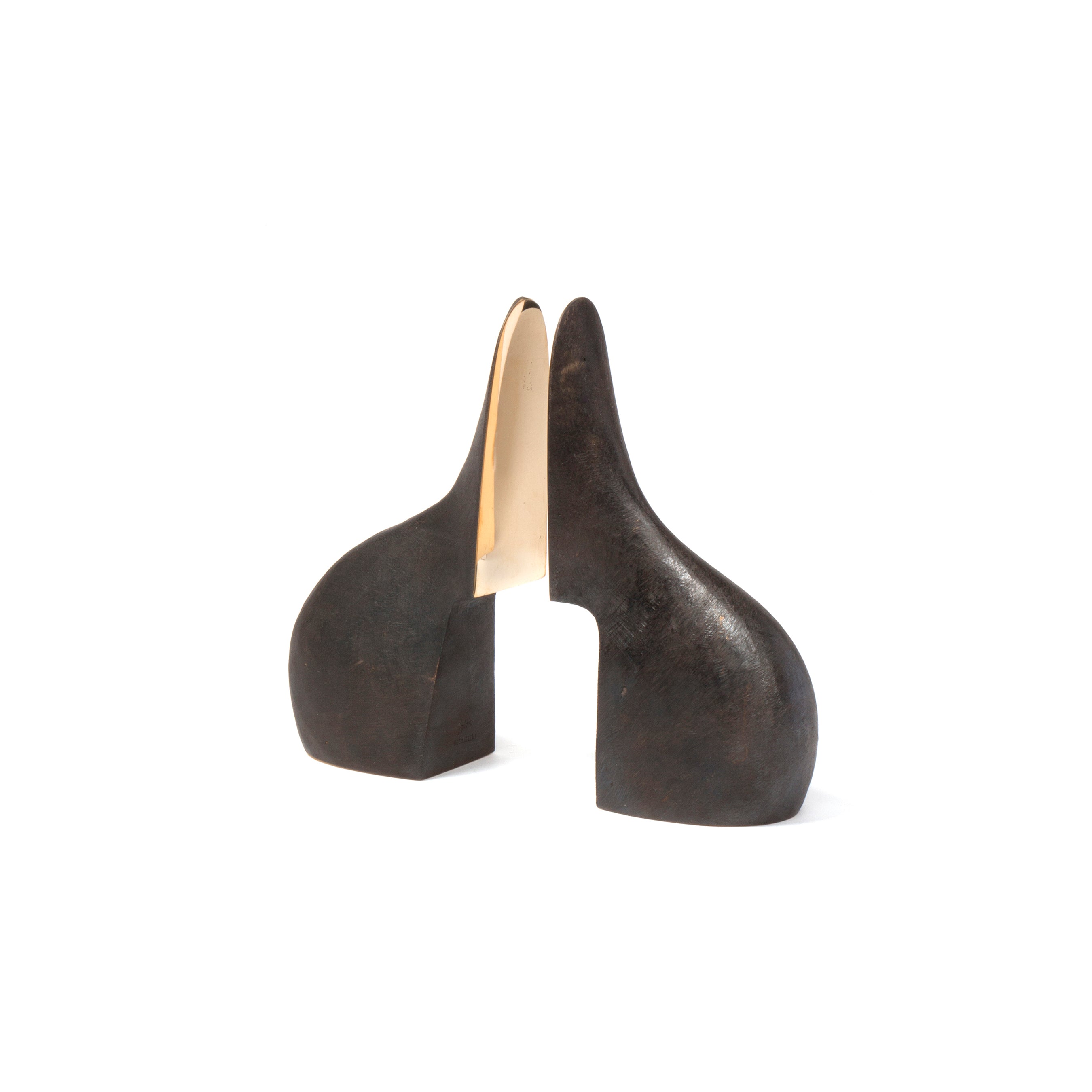 Crafted by Werkstätte Carl Auböck, the Pair of Bookends #3652 features two curved, dark forms with a narrow gap. The smooth, golden inner surface contrasts strikingly with the dark exterior, reminiscent of Wiener Bronzen pieces shown at Triennale di Milano.