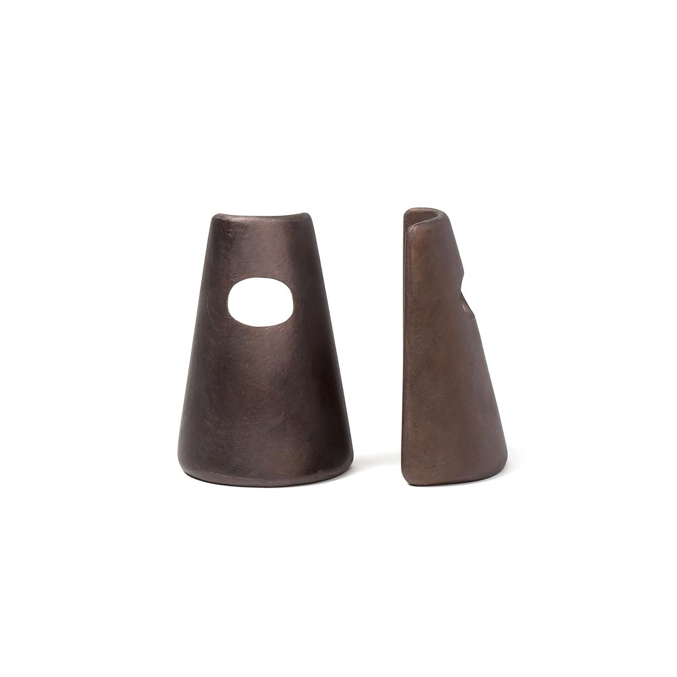 The Pair of Bookends #4843 by Werkstätte Carl Auböck, two brown ceramic sculptures with a cone shape, reflect the minimalist elegance of a Viennese townhouse. One has a large circular hole near the top, adding intrigue against their smooth surfaces on a plain white background.