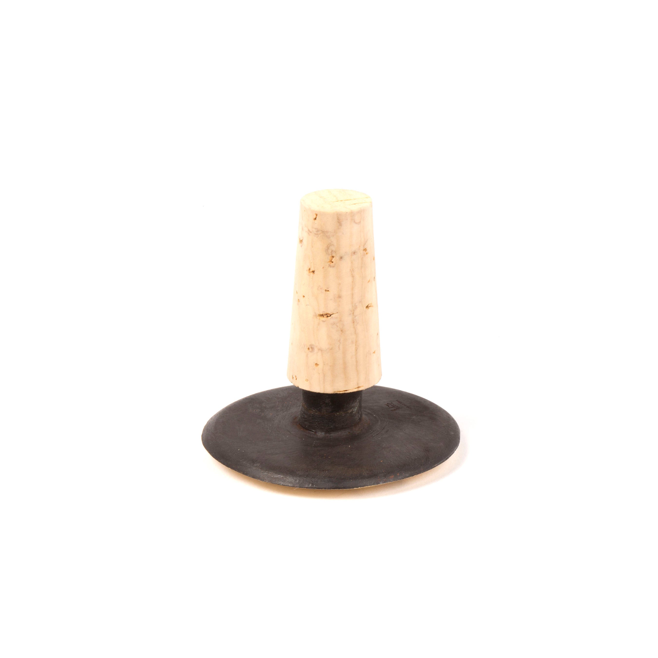 The Corkstopper Face #4682 by Werkstätte Carl Auböck is a vintage black rubber kitchen tool with a wide base and tapered light wooden handle, evocative of classic designs found in Viennese townhouses for food mashing or pressing.