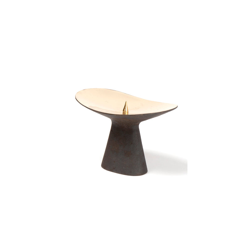 A minimalist sundial from Werkstätte Carl Auböck features a light bowl-shaped face with a dark, tapered cylindrical base and a central golden triangular gnomon on a plain white background.