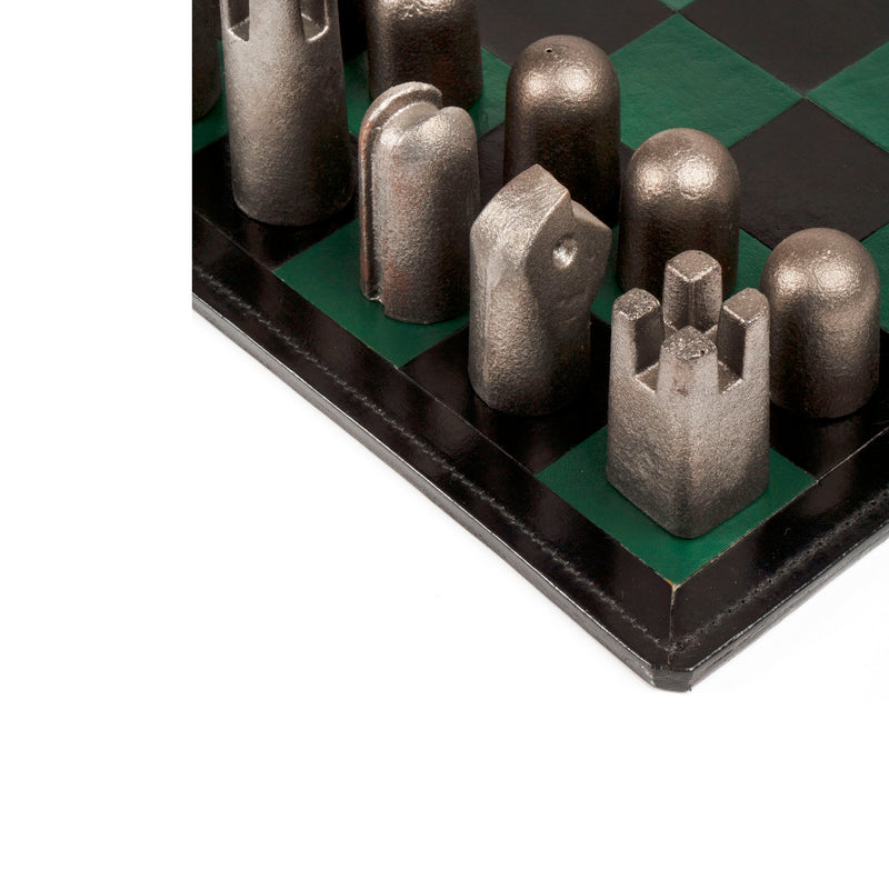 Close-up of Chess Board and Chess Pieces #5606 by Werkstätte Carl Auböck, featuring abstract, metallic pieces and a green and black board, inspired by Wiener Bronzen in modern artistic forms.