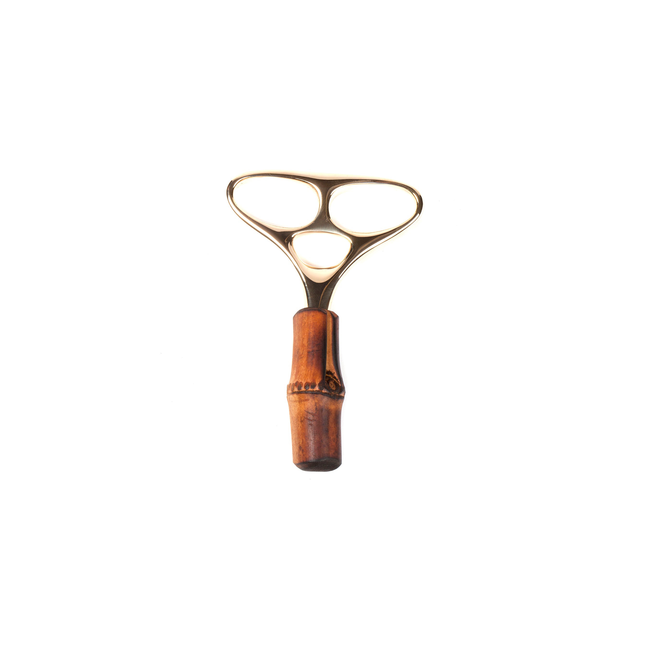 The Werkstätte Carl Auböck Corkscrew Skull #4230 is a bronze-colored, three-holed tool with an elegant design, featuring a wooden handle and a unique loop for versatile gripping or massaging, set against a pristine white background.