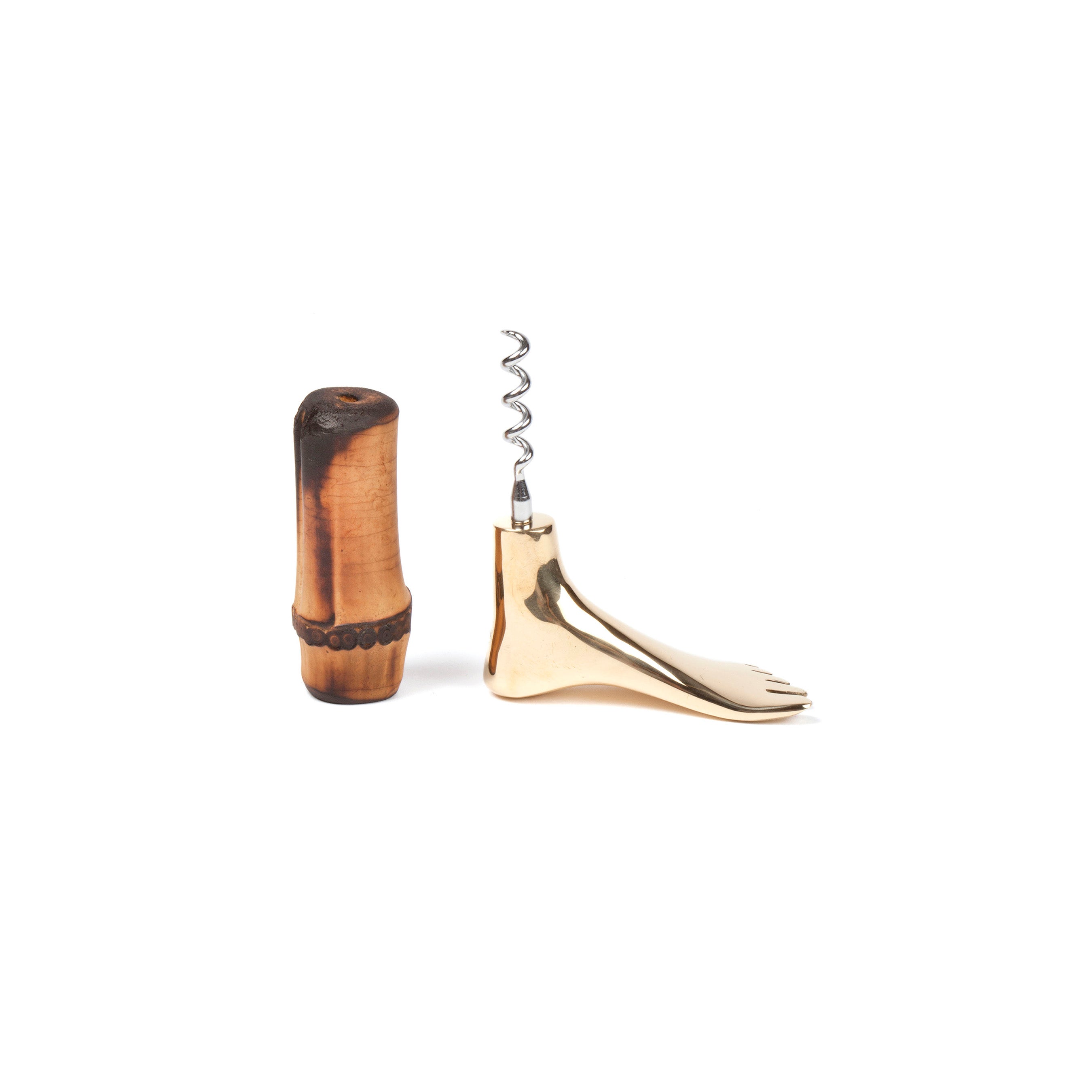 The Corkscrew Foot #4275M by Werkstätte Carl Auböck features a polished metal coil and foot-shaped base, elegantly displayed on a wooden stand, echoing the timeless decor of a Viennese townhouse against a pristine white background.