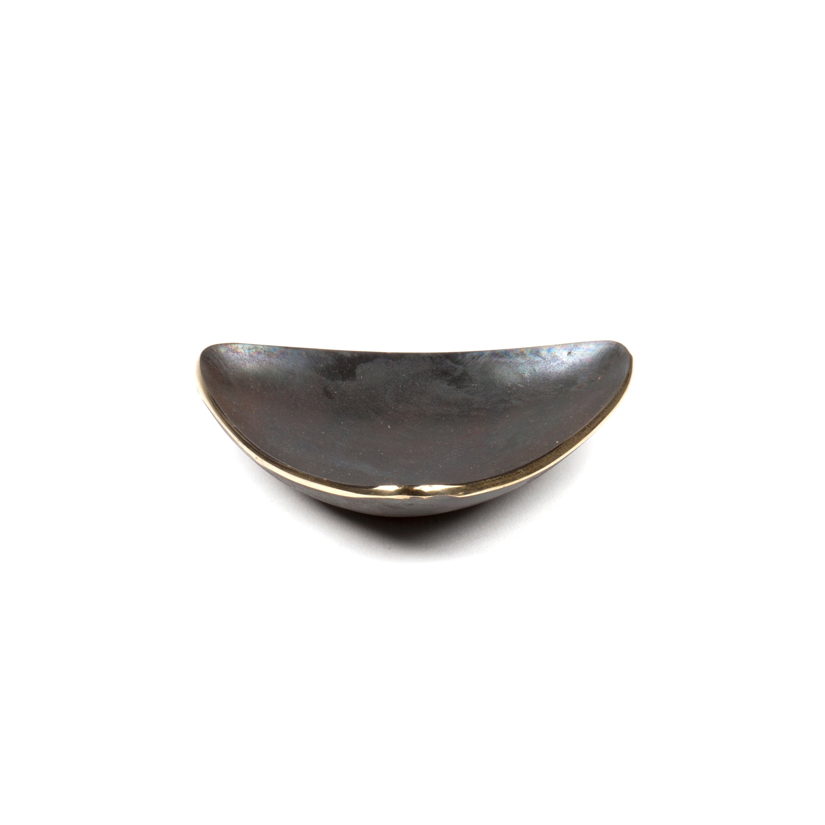 Dish #3844 by Werkstätte Carl Auböck is a small, crescent-shaped, dark stone piece with a smooth surface, resembling a worry stone. It rests elegantly on a plain white background.