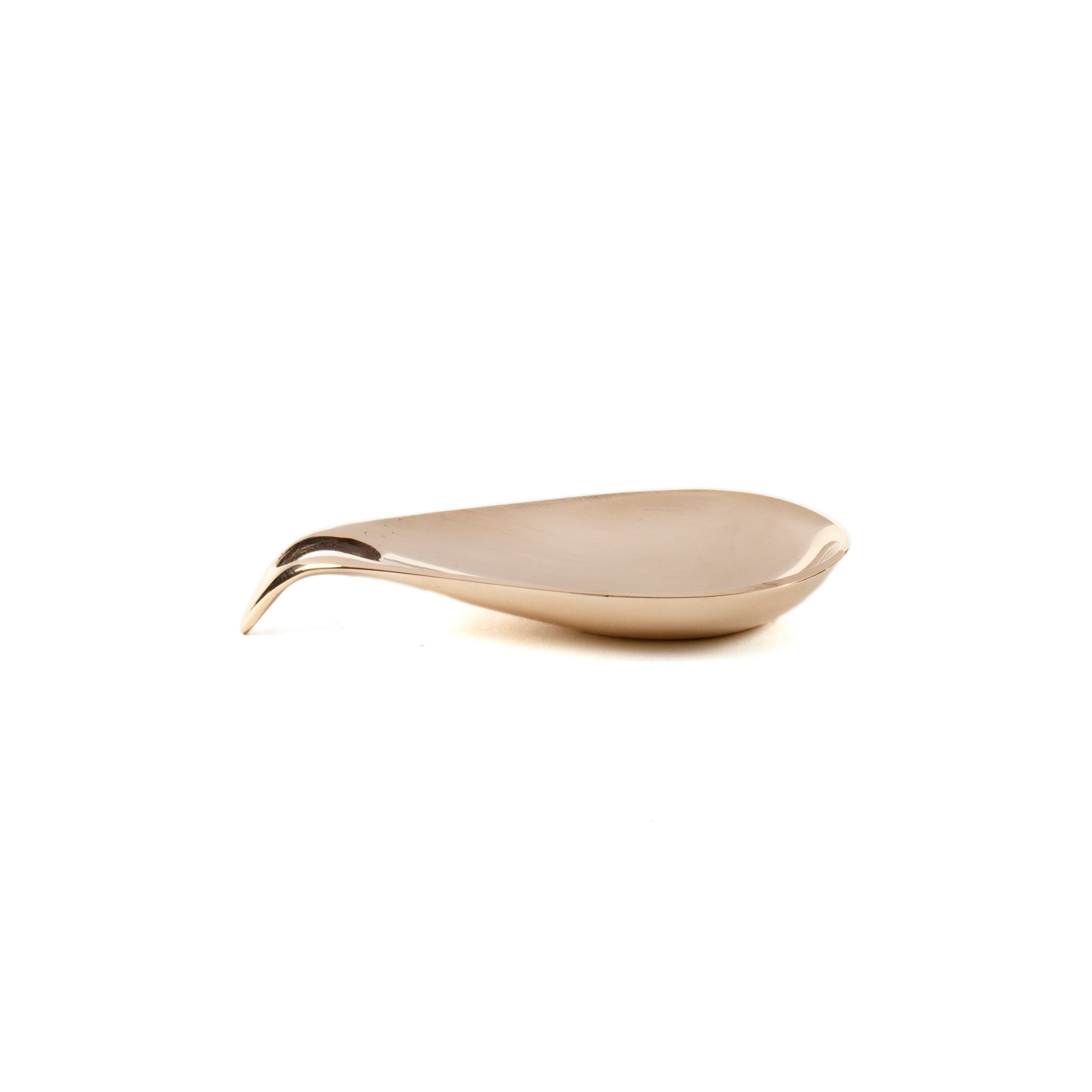 The Dish #3904 by Werkstätte Carl Auböck is a sleek, modern shoehorn with a smooth metallic finish. Elegantly curved, it rests against a plain white background, reflecting the timeless charm of a Viennese townhouse.