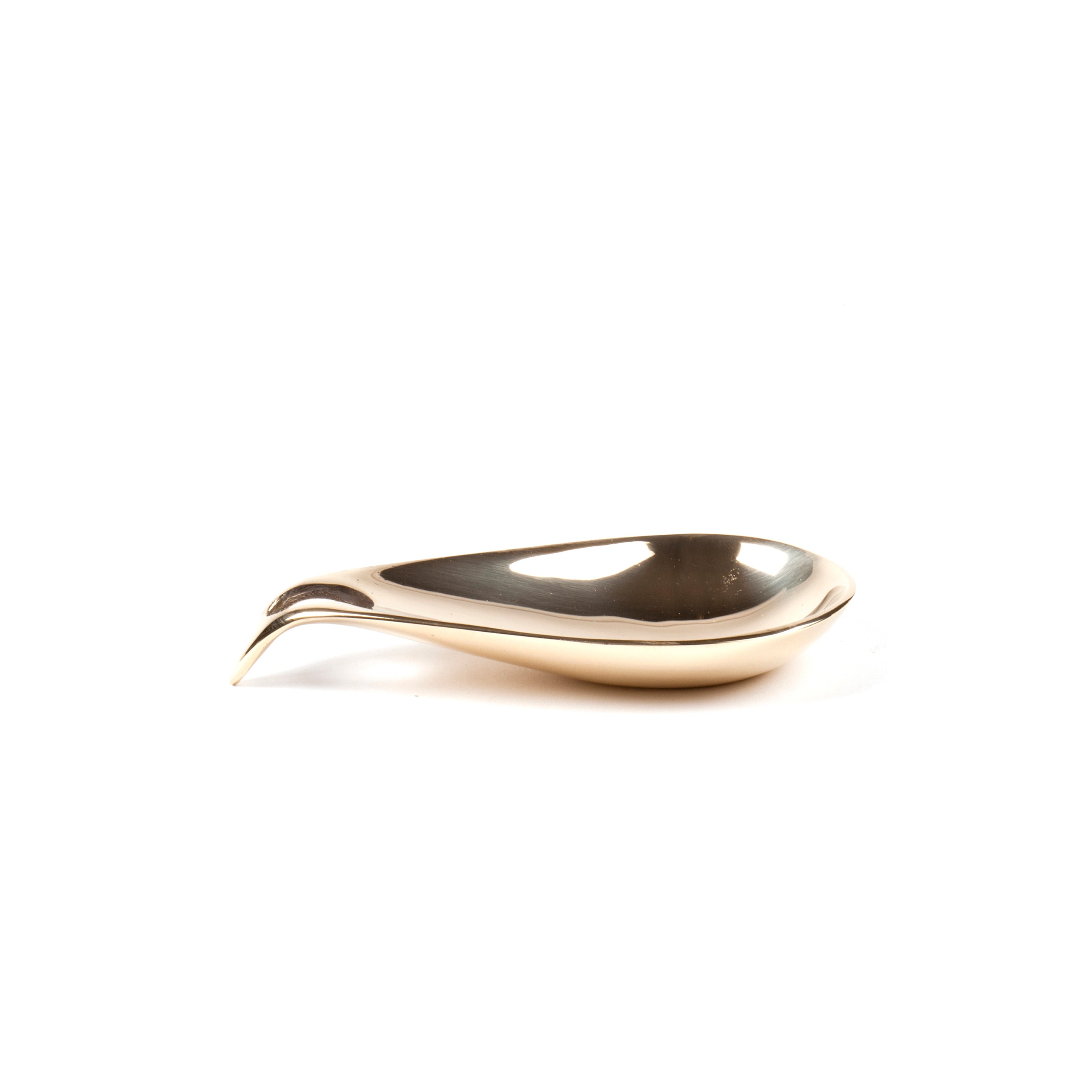 The sleek Dish #3904 by Werkstätte Carl Auböck features a modern metal spoon with a curved handle, lying on a flat surface. Its smooth, shiny finish reflects light, embodying an elegant, minimalist style reminiscent of Wiener Bronzen artistry.
