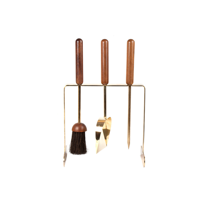 The Fireplace set #6090 by Werkstätte Carl Auböck features three elegant tools with wooden handles—brush, shovel, and poker—set on a sleek stand. With metallic details, it captures the charm of a Viennese townhouse.