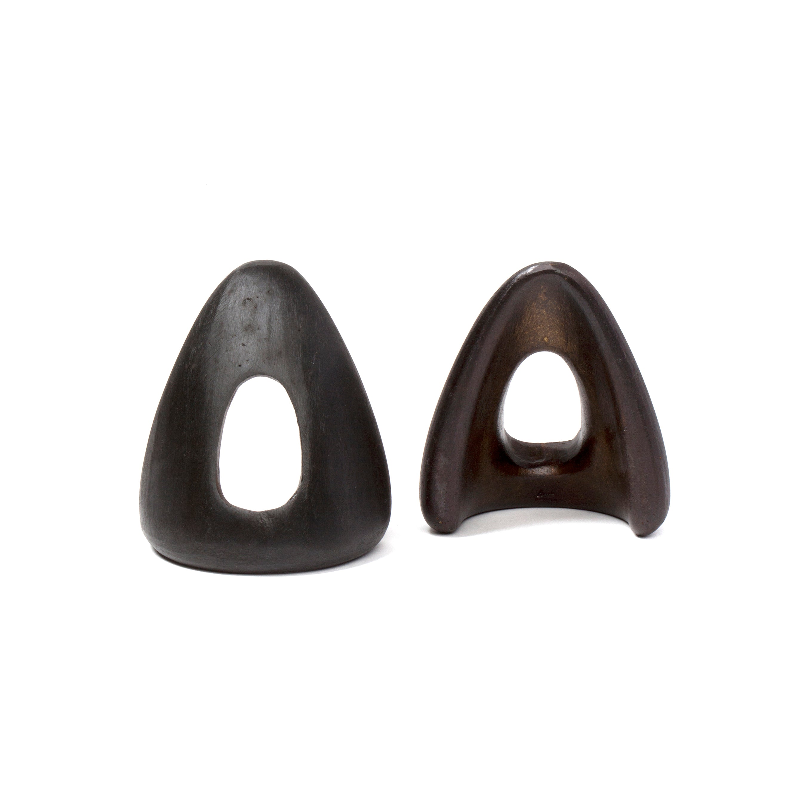 The Pair of Bookends #4635 by Werkstätte Carl Auböck features two black ceramic sculptures with hollow, abstract triangles on a white background. The left is smooth, and the right has a glossy finish, reminiscent of pieces celebrated at the Triennale di Milano.