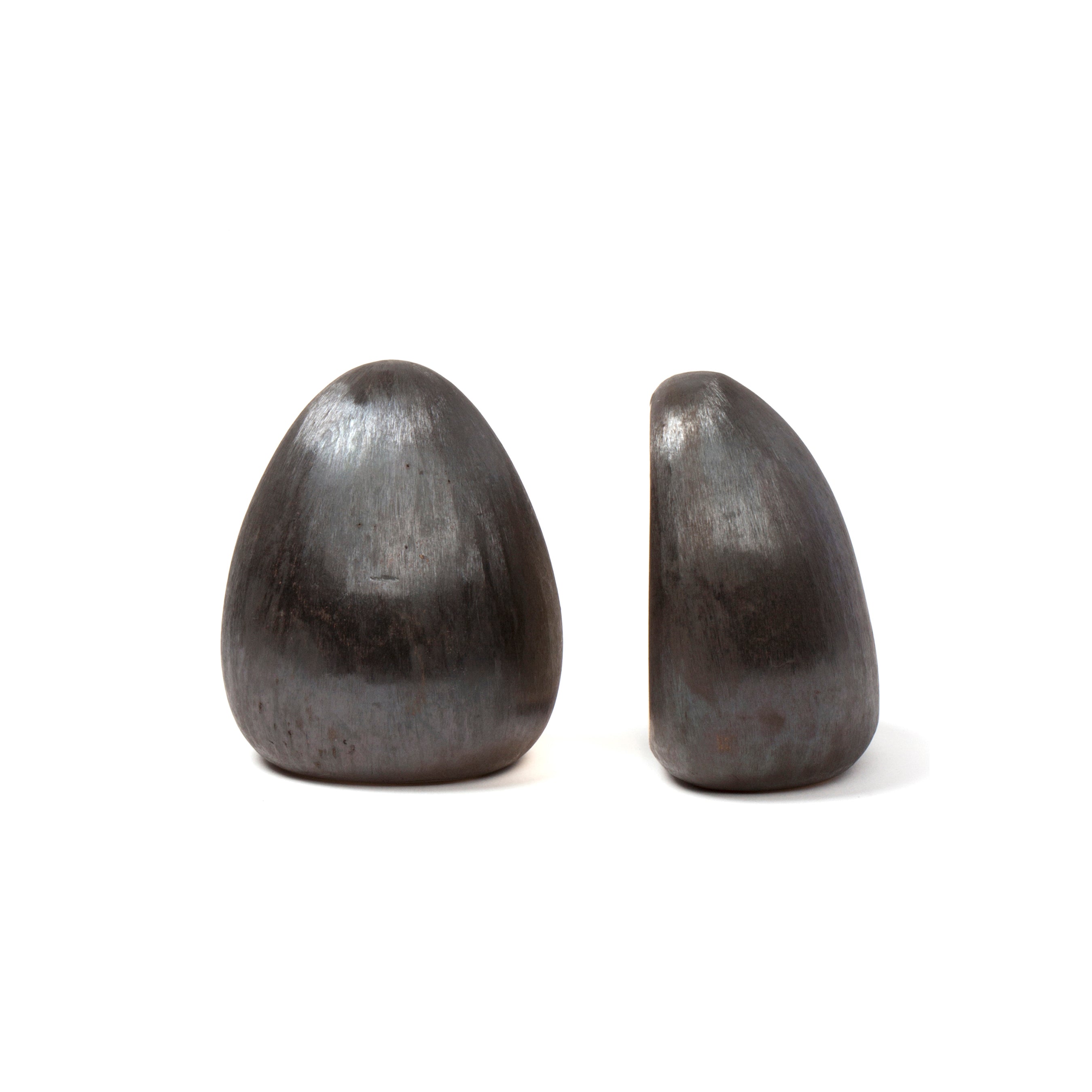 Displayed against a white background, the Pair of Bookends #4636 by Werkstätte Carl Auböck are polished, smooth metallic sculptures with rounded abstract shapes—one slightly taller than the other—evoking the elegance of a Viennese townhouse.