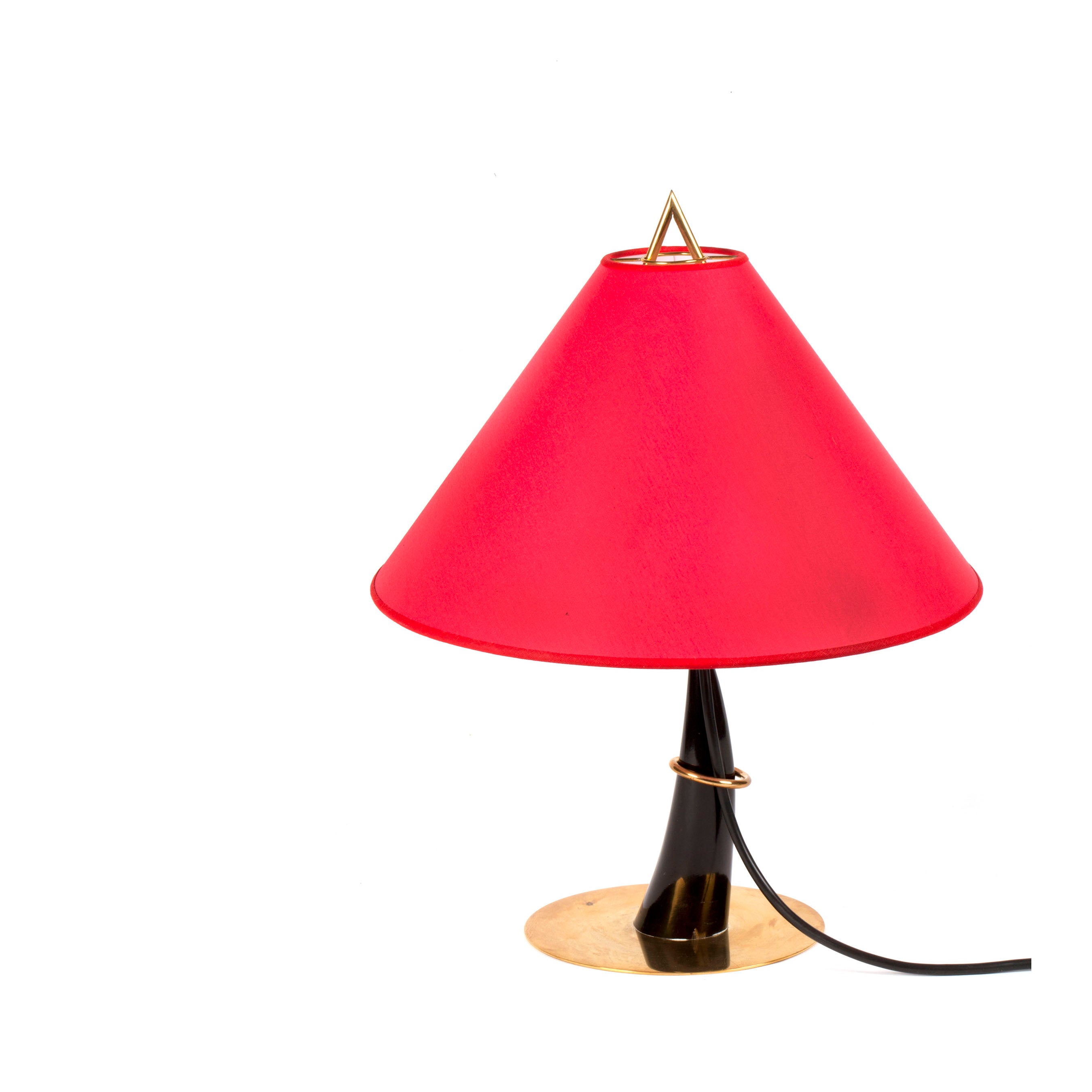 The Table lamp Horn #7255 by Werkstätte Carl Auböck features a bold red conical shade, sleek black stand, and brass-colored base and top accent. Its visible power cord elegantly trails downwards, reminiscent of Triennale di Milano 1954 aesthetics.