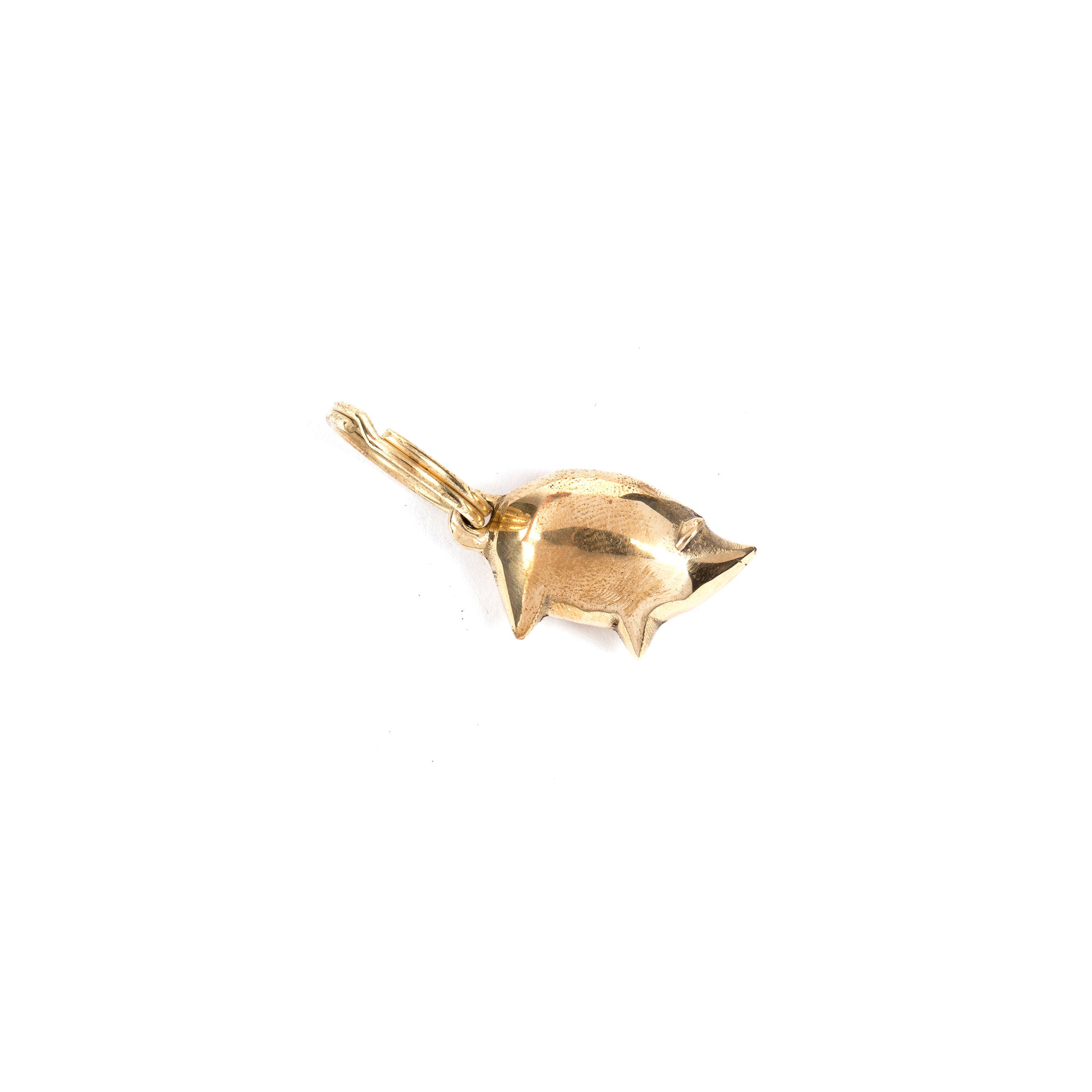 The Keyring Pig #4500 by Werkstätte Carl Auböck, reminiscent of Wiener Bronzen, is a charming gold pig-shaped accessory featuring a small loop for easy attachment to a bracelet or necklace.