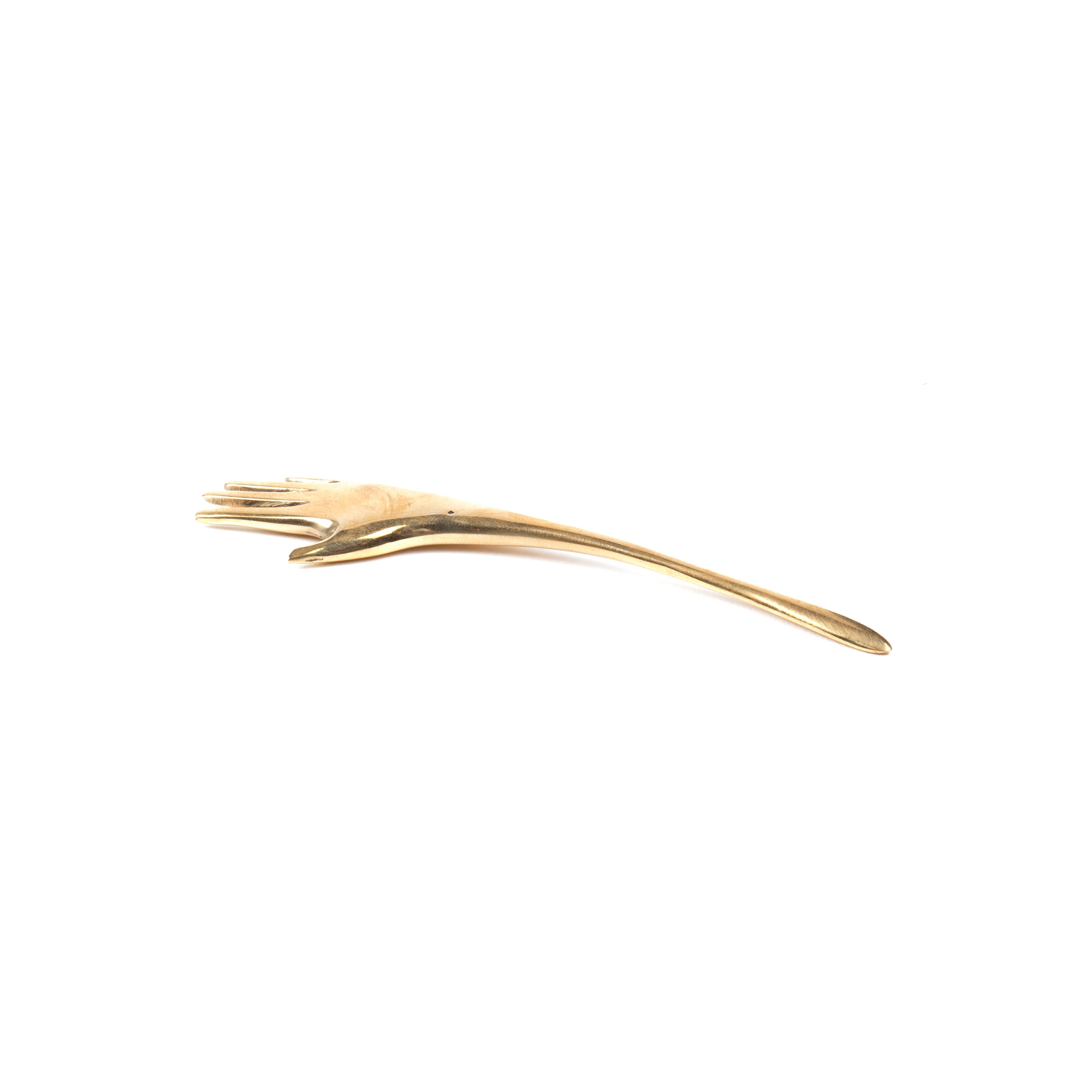 The Letter Opener Hand #7208 by Werkstätte Carl Auböck resembles a gold spoon shaped like a hand, with the handle featuring detailed fingers, echoing the elegance of his Viennese townhouse designs against a plain white background.
