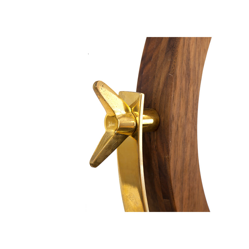 A close-up of Mirror #4959 by Werkstätte Carl Auböck shows a brass propeller with three blades on a polished gold bracket, mounted on a wooden base. The smooth brown finish and white backdrop echo the elegance of Viennese townhouses.