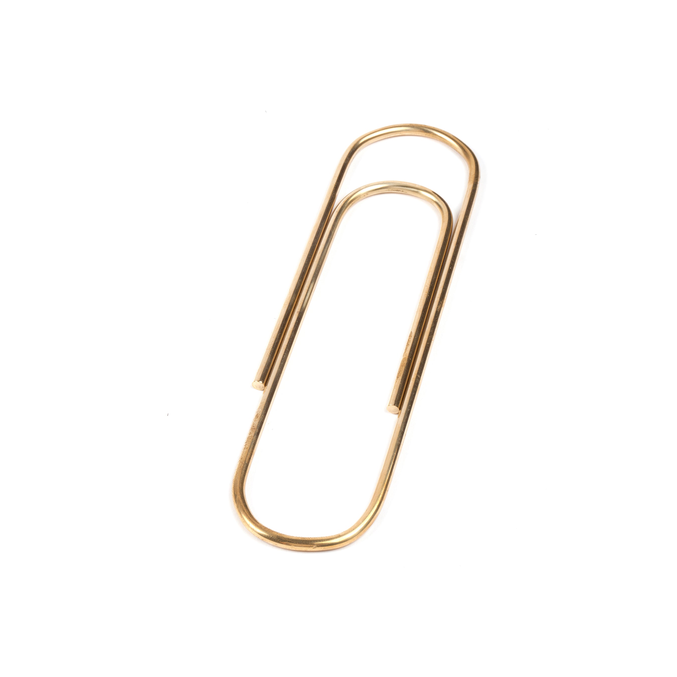 The Paper Clip #4751 by Werkstätte Carl Auböck, showcasing a classic brass design, rests elegantly on a white background.