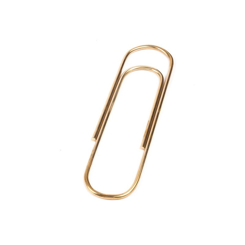The Paper Clip #4751 by Werkstätte Carl Auböck, showcasing a classic brass design, rests elegantly on a white background.